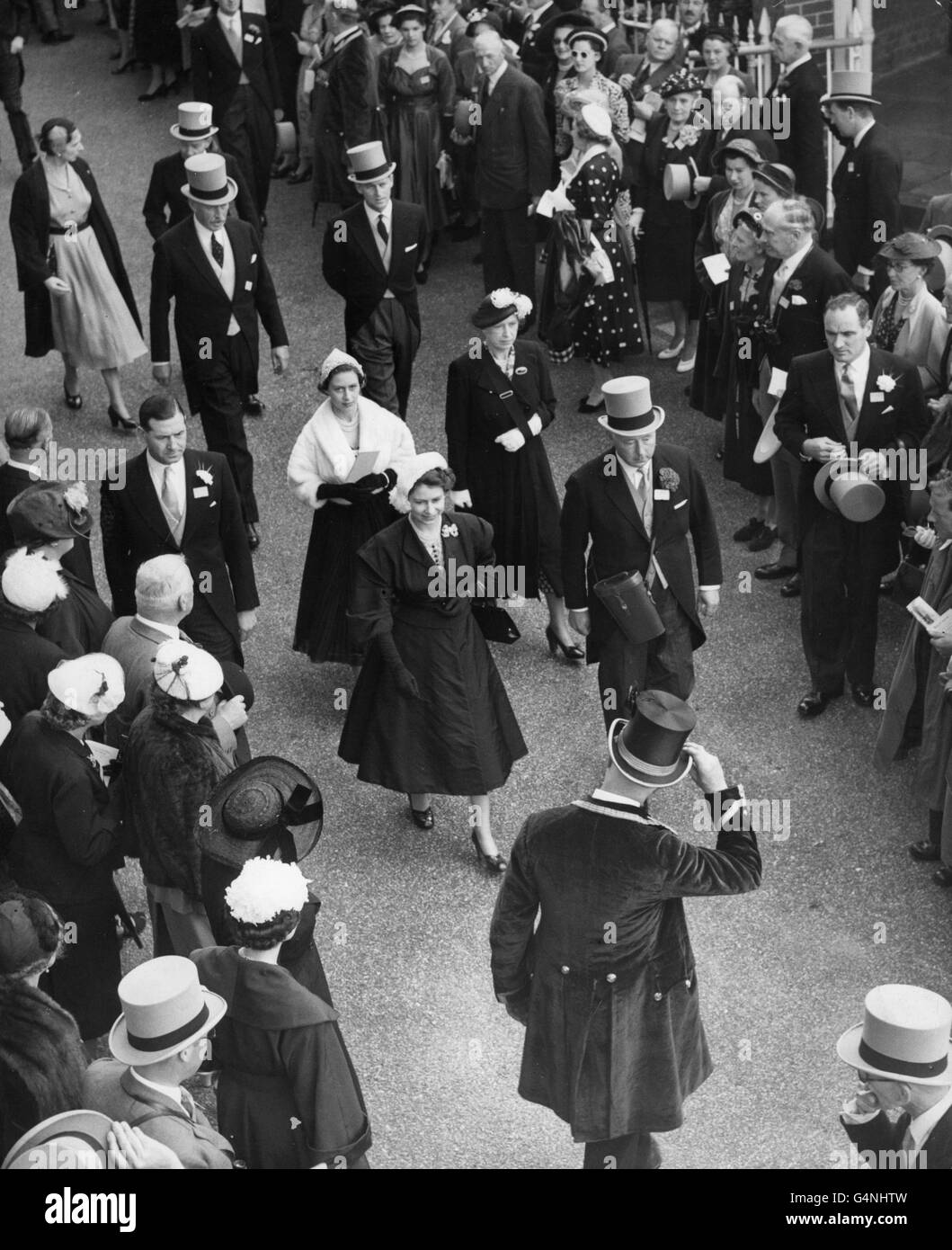 Queen Elizabeth II, dressed in black with a white hat, followed by Princess Margaret and the Princess Royal (with hand in a sling), near the Paddock at Ascot Racecourse, on the second day of Royal Ascot meeting. Behind the Princess Royal is the Duke of Edinburgh. Stock Photo