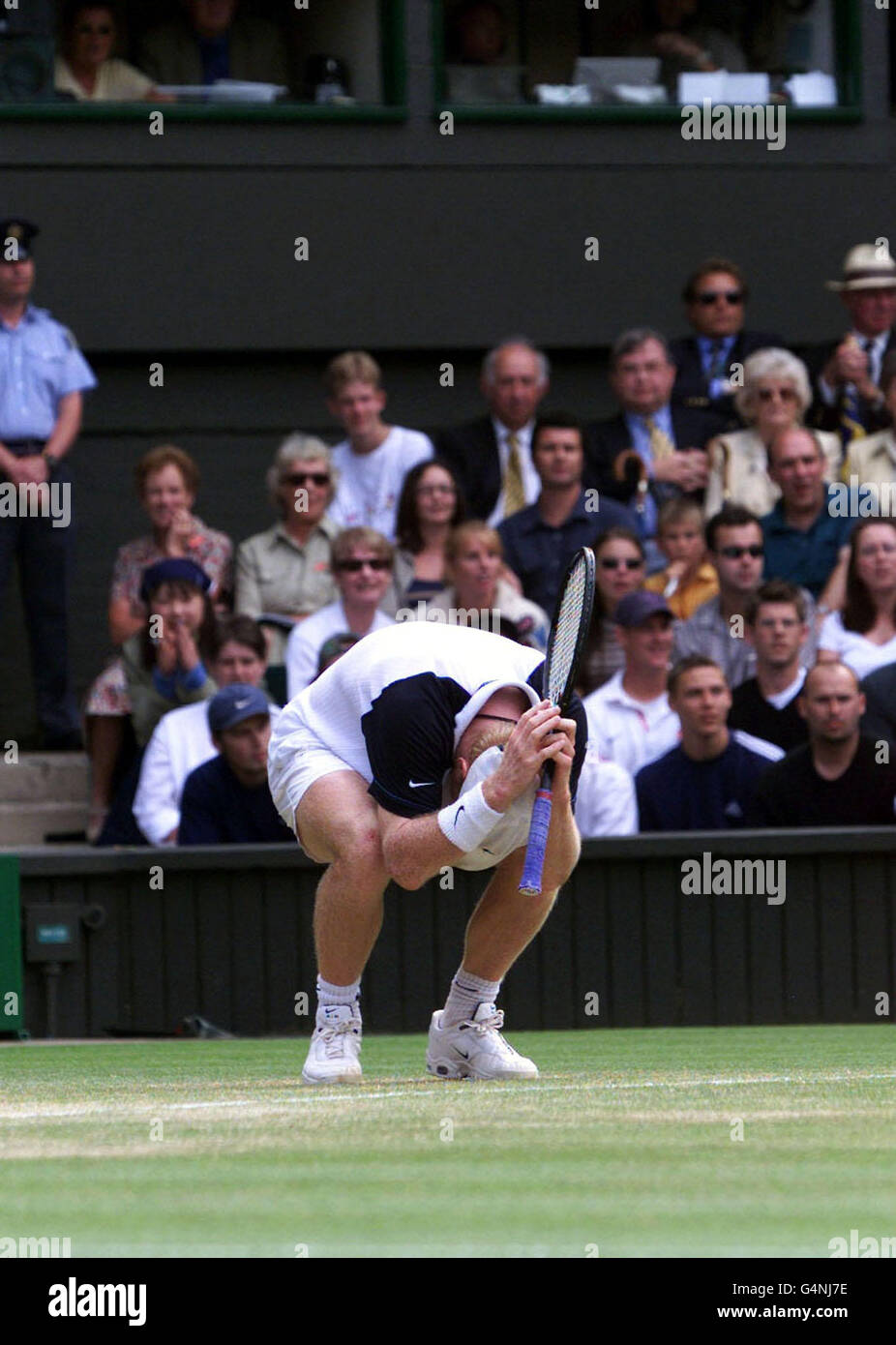 No Commercial Use. America's Jim Courier crouches on the baseline in disbelief after a close line call that went against him during the final game of the marathon 5 set match against Tim Henman at the Wimbledon. Stock Photo