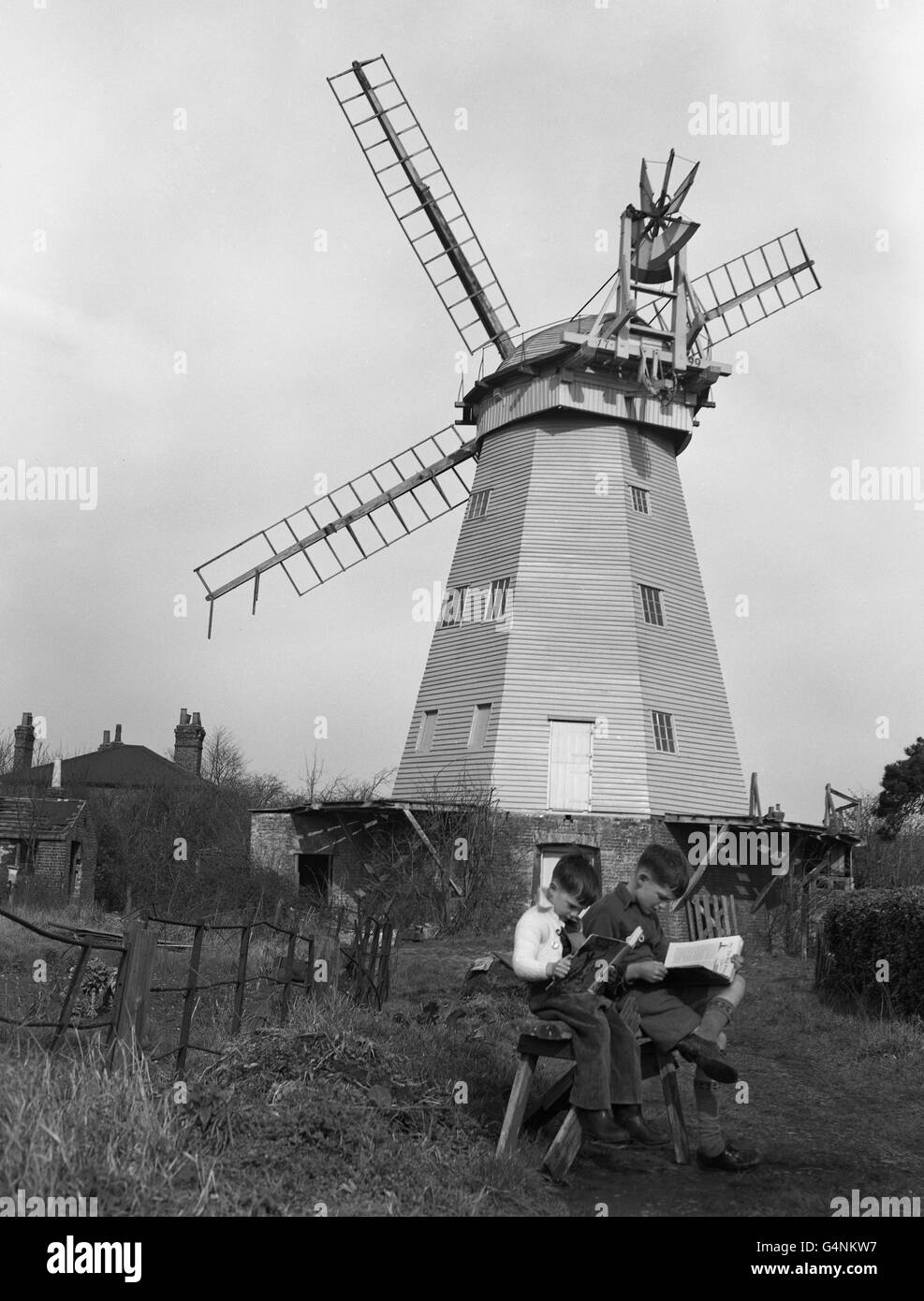 A windmill gets a new lease of life. Four-year-old David Norris (l) and his brother Norman, 9, will not be losing the sight of the 150-year-old windmill, which is just beyond the end of their garden in Upminster, Essex . The mill, threatened with decay through lack of use, has been acquired by the county council. It is now being renovated and the cost shared by the local and county councils. Stock Photo