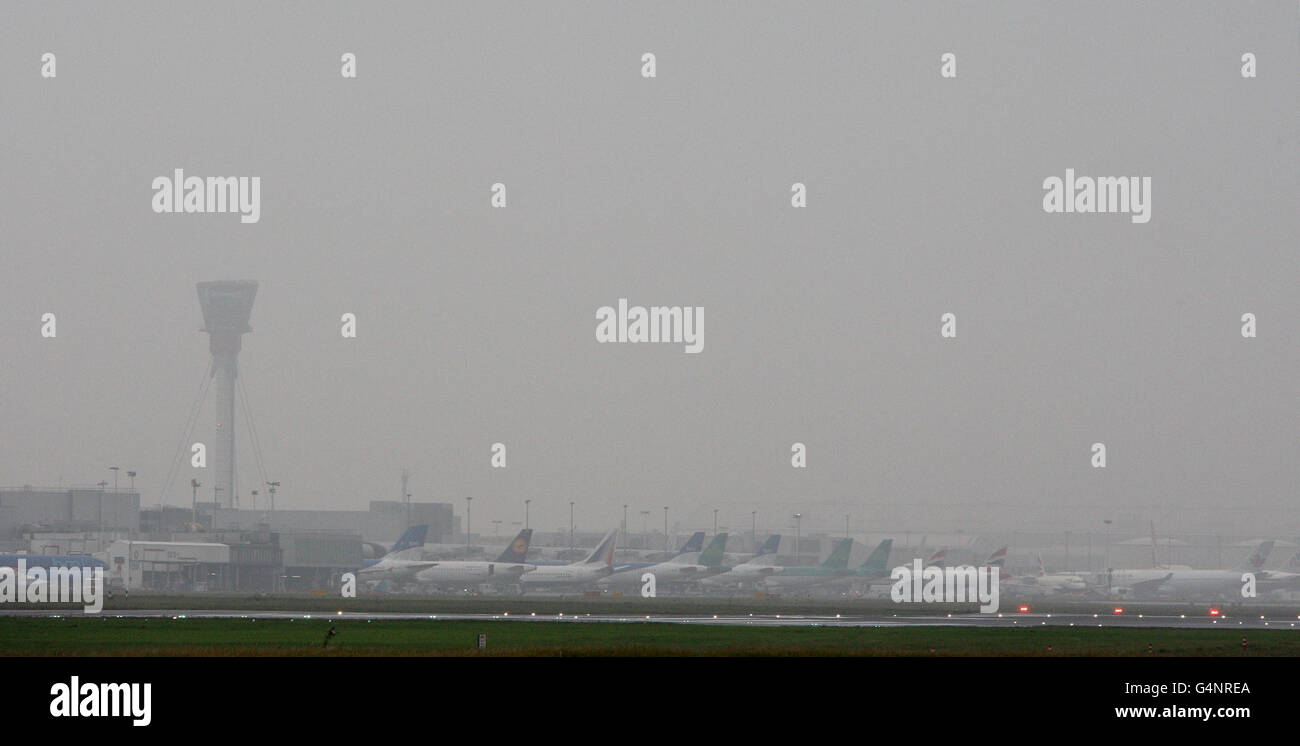 Planes on the tarmac in fog at Heathrow Airport, London today. Stock Photo