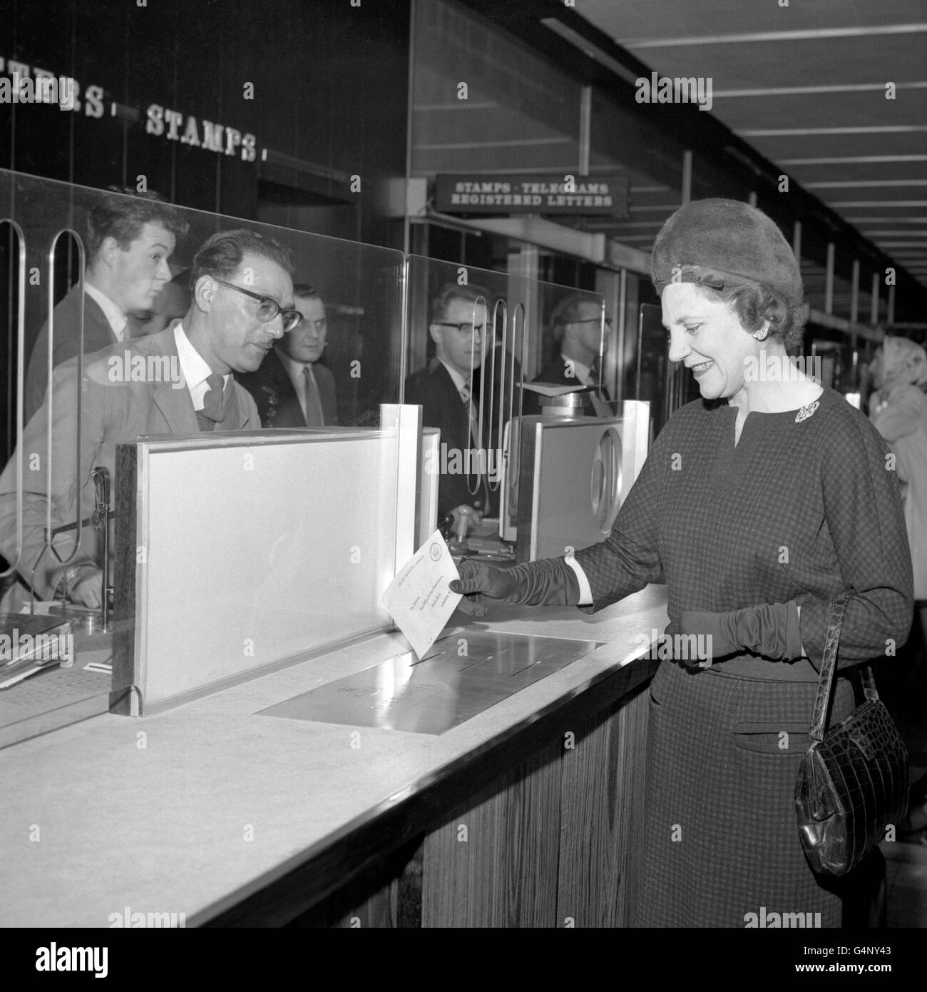 Miss Mervyn Pike, Assistant Postmaster-General, posts a letter in one of the slots especially placed at the counter of the new Trafalgar Square Post Office in William IV Street, London Stock Photo