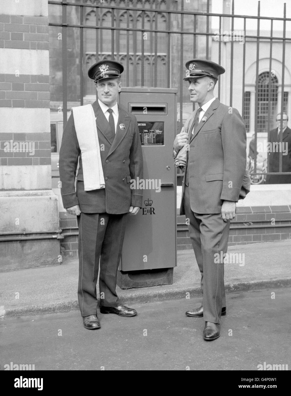 Postman Leslie Buxton (right) dressed in the new grey single breasted postmen's uniform, which will appear in the Spring of 1969. Alfred Buxton (left, no relation to Leslie) wears the present double breasted blue uniform. The two men are seen with a new design of pillar box which is to be tried out by the Post Office Stock Photo