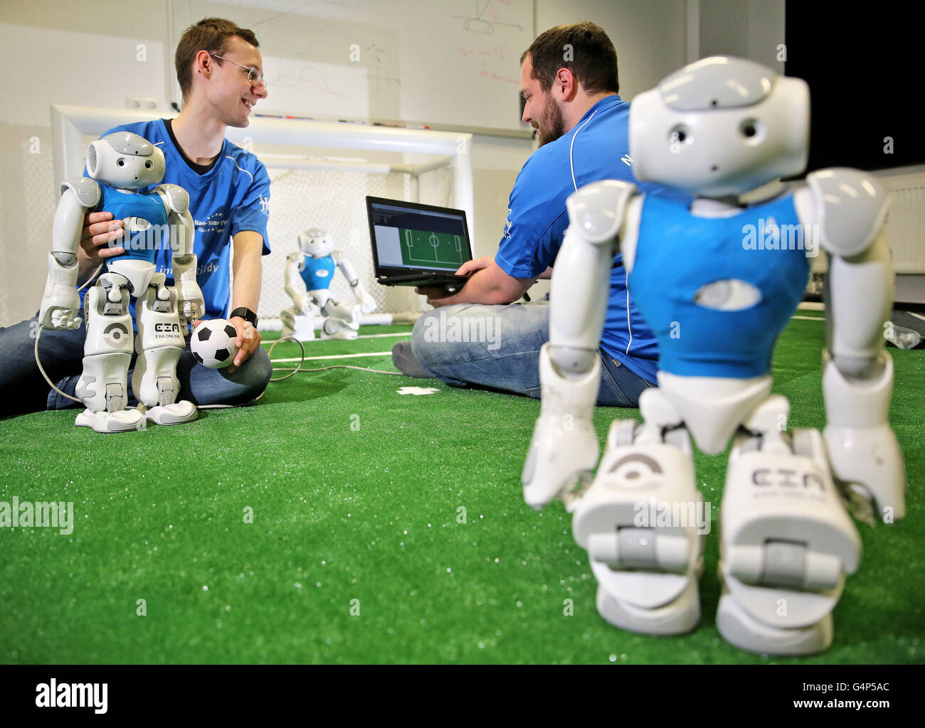 Leipzig, Germany. 31st May, 2016. Florian Mewes (r) and Hannes Hinerasky of the HTWK team preparing Nao-Robots for a test match on new turf at a lab of the University for Technology and Economy in Leipzig, Germany, 31 May 2016. The team participated in the World Robot Soccer Championship several times. Now they prepare for the 20th RoboCup that will be held in Leipzig between 30 June and 4 July. Roughly 3.5000 participants and 500 teams from 40 countries are expected. PHOTO: JAN WOITAS/dpa/Alamy Live News Stock Photo