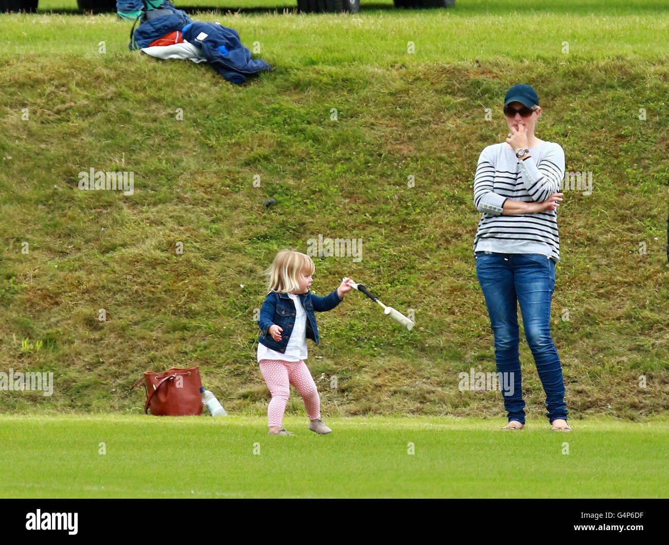 Zara Tindall and Mia . . Tetbury, Gloucestershire . . 18.06.2016 Mia Tindall (2) plays with a polo stick and ball near her mother Zara Tindall (Philips), eldest granddaughter of HM Queen Elizabeth II. Her Uncle, Prince William, Duke of Cambridge, played polo, and Uncle Prince Harry (of Wales), supported his brother.  Credit:  Paul Marriott/Alamy Live News Stock Photo