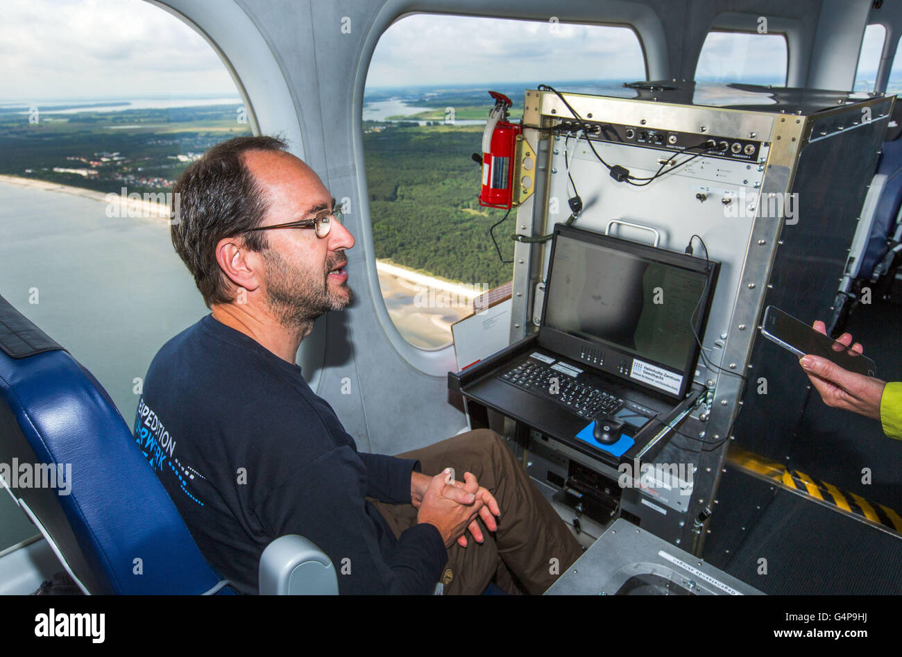 Geesthacht, Germany. 19th June, 2016. In the control centre of a zeppelin the biological oceanographer Ruediger Roettgers works during a measurement flight over the Baltic Sea from the Peenemuende airfield in Peenemuende, Germany, 19 June 2016. The incoming measurements belong to an expedition for the research of marine vortices. The 75-meter-long airship is equipped with special high-resolution cameras, with which the smallest temperature differences of 0.03 degrees and colour differences can be registered in the water. The researchers collect data on the influence of unstable small sea swirl Stock Photo