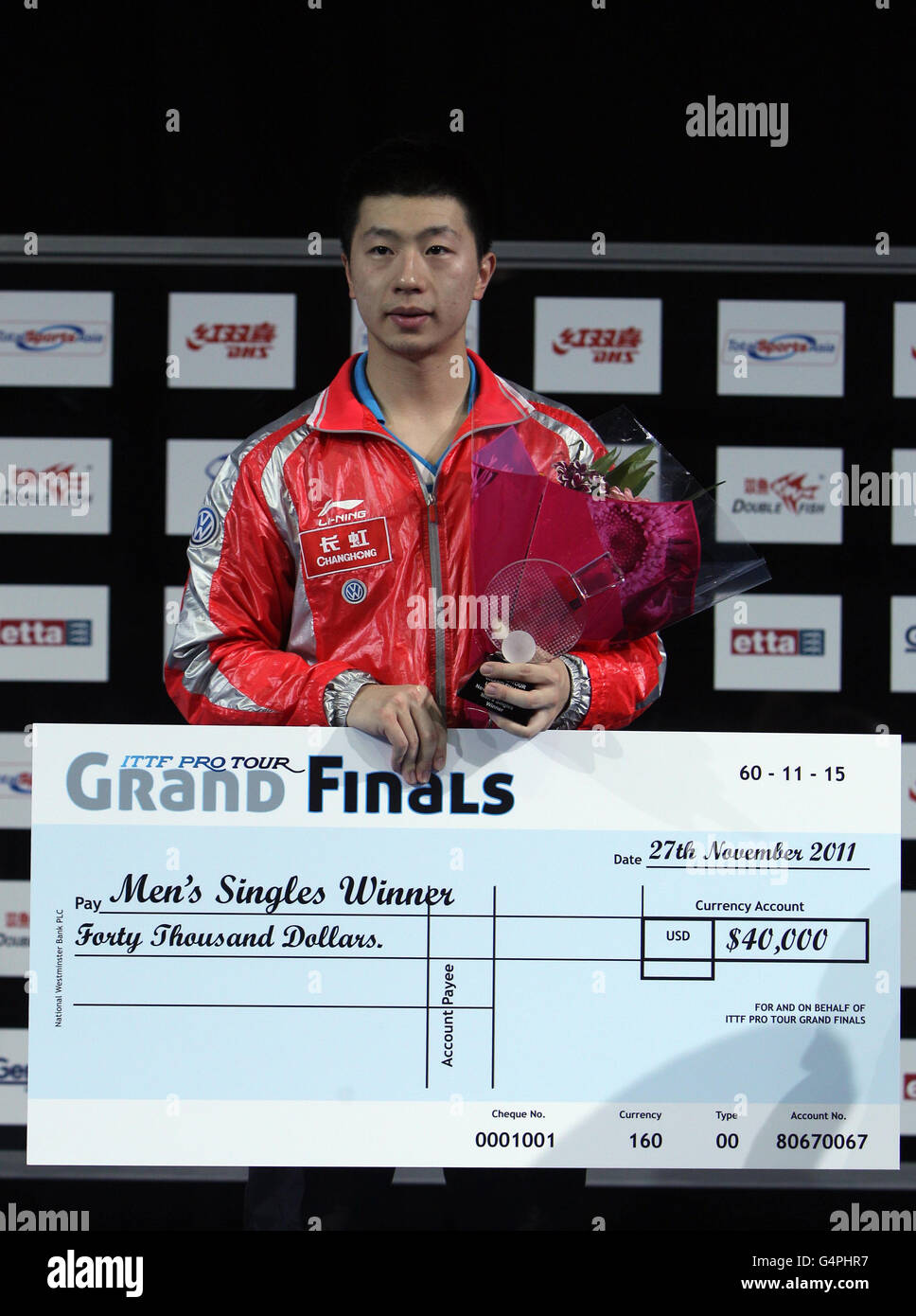 Olympics - Table Tennis - London 2012 Test Event - ITTF Pro Tour Grand Finals - Day Four - Excel Arena. China's Ma Long celebrates victory and receives a cheque for winning the final of the ITTF Pro Tour Grand Finals at the Excel Arena, London. Stock Photo