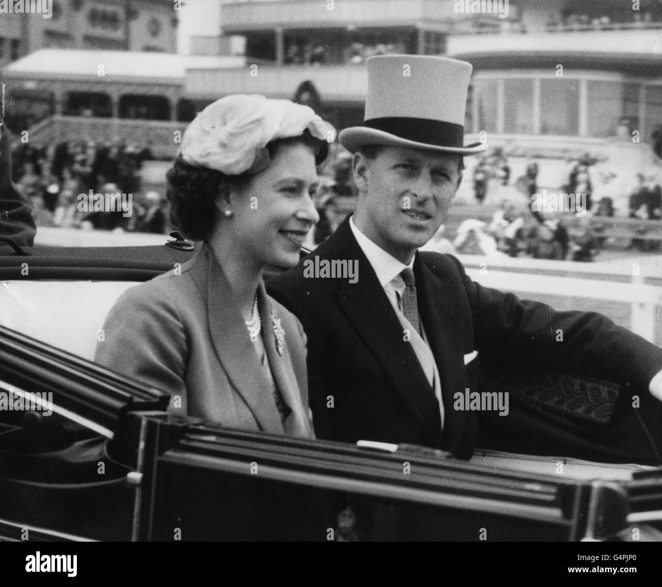 Queen Elizabeth II and the Duke of Edinburgh drive in their open carriage along the course at Ascot to watch the racing on the last day of the Royal Ascot meeting. Stock Photo
