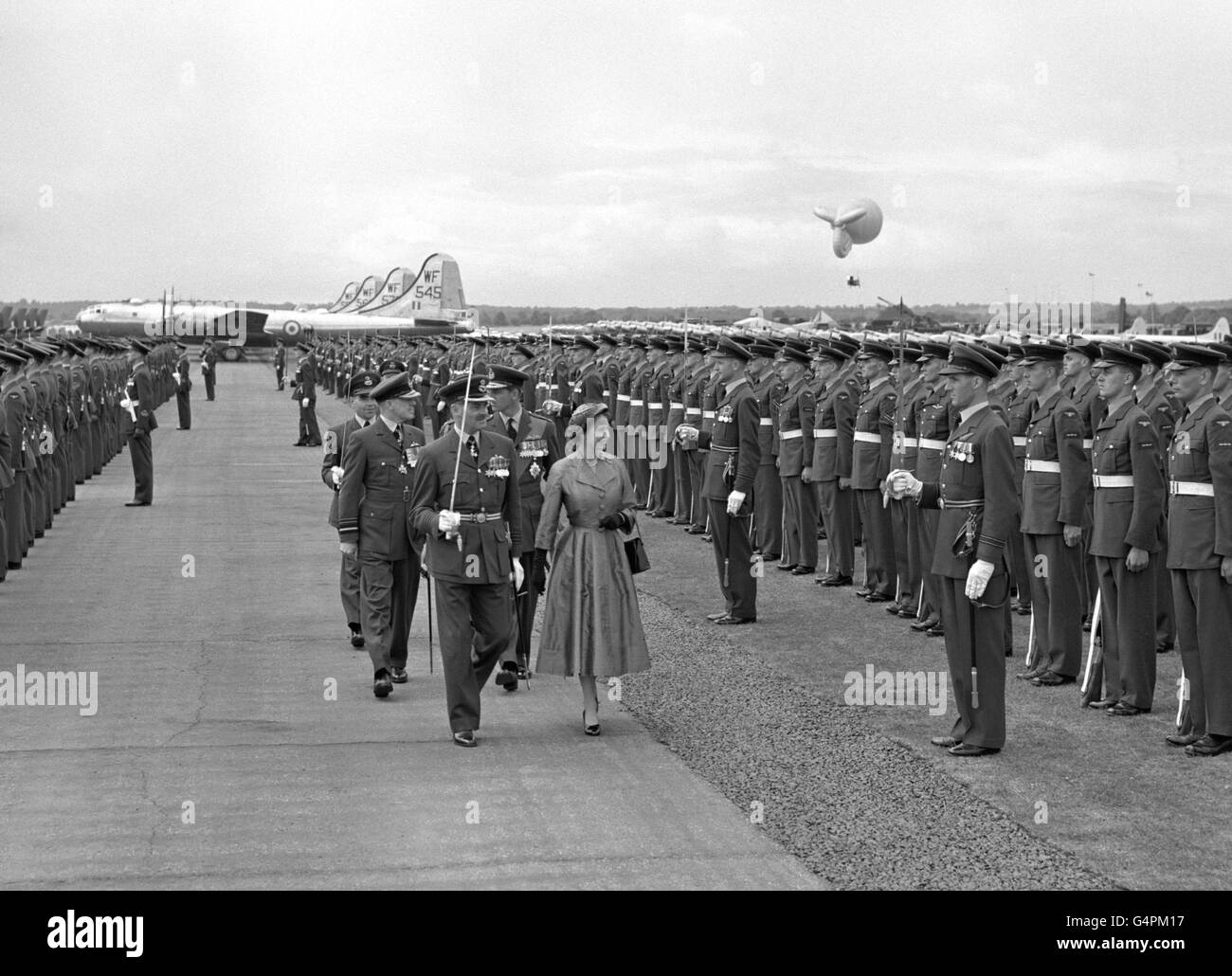 Queen Elizabeth II reviewing the Royal Air Force at Odiham Airfield, lined up with the mass of planes in the background. Following behind the Queen is the Duke of Edinburgh, in marshal of the RAF uniform. Stock Photo