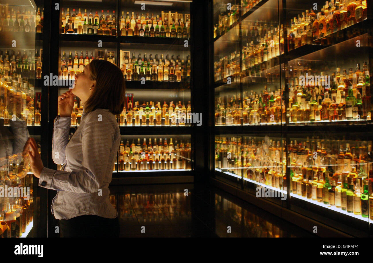 Staff member Gillian Armstrong looks at some of the worlds largest Scotch Whisky collection at the Scotch Whisky Experience in Edinburgh, as the value of Scotch whisky exports reached almost £3 billion in the first nine months of this year, an increase of 23% on the same period in 2010. Stock Photo