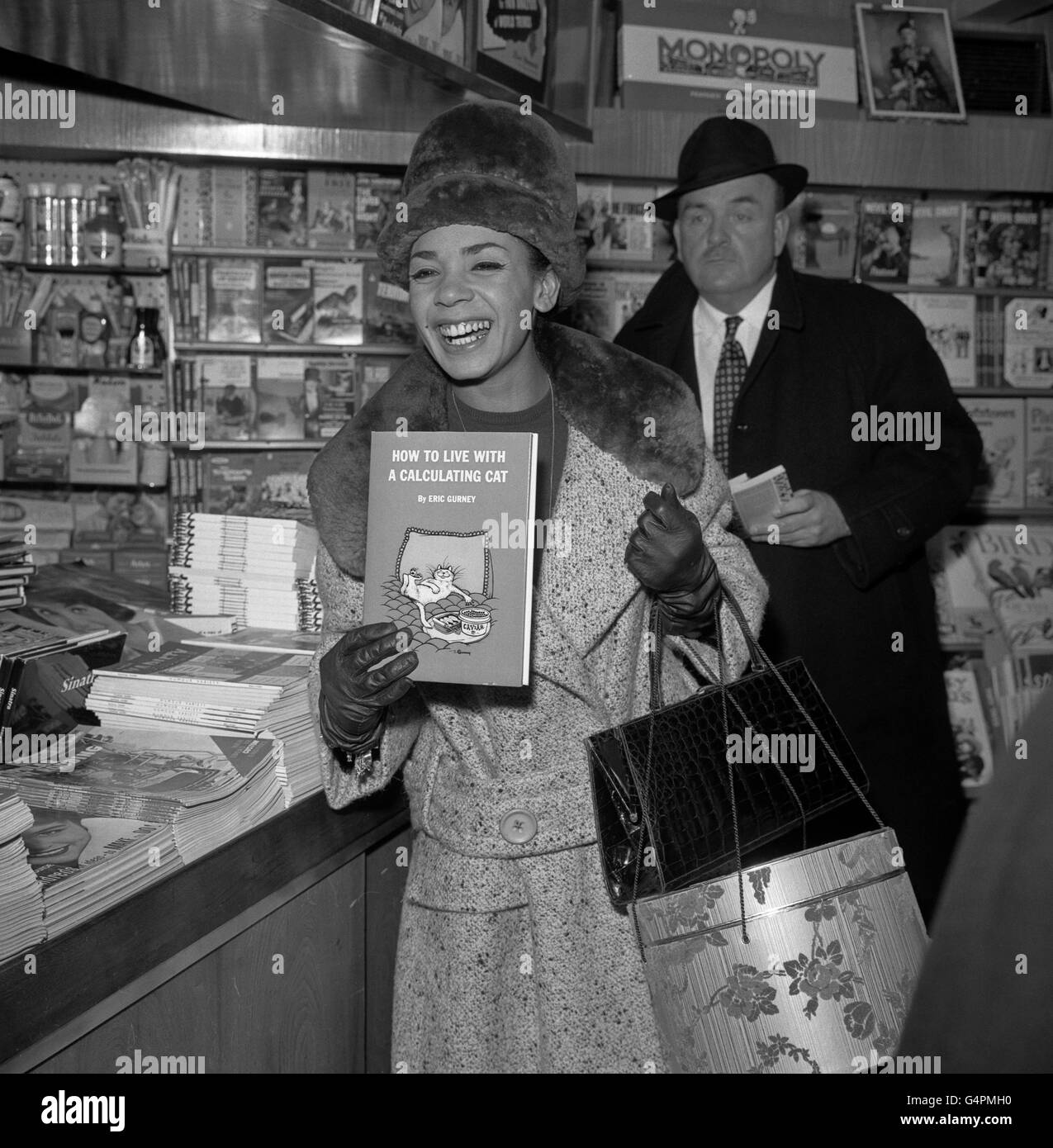 Last night's upset apparently forgotten, singer Shirley Bassey is evidently pleased with her choice of literature at the London Airport bookstall. She was flying to New York to fulfill a four weeks cabaret engagement. At the Savoy Hotel last night, Shirley left the stage very upset after complaining to her audience during a party celebrating the tenth anniversary of the London run of the play, The Mousetrap'. Shirley was appearing in the cabaret at the party and during her act said to the audience 'It is like an auction room at the back'. Stock Photo