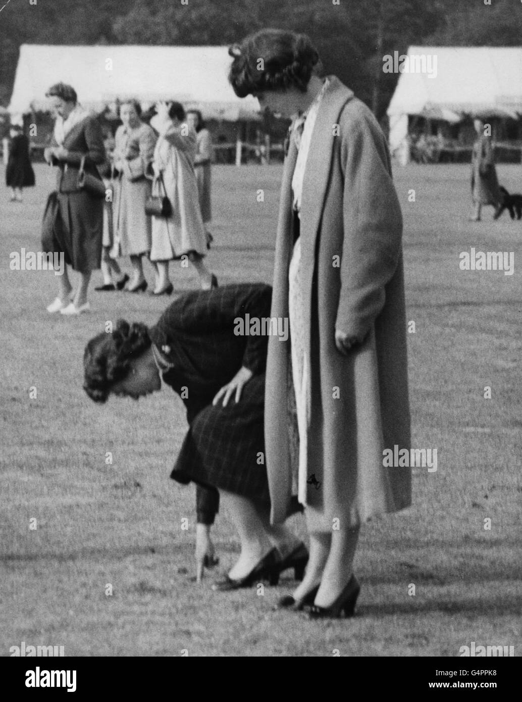 Queen Elizabeth II joining members of the public on a polo ground at Smith's Lawn, Windsor Great Park, to tread down pieces of turf torn up by the ponies. Stock Photo
