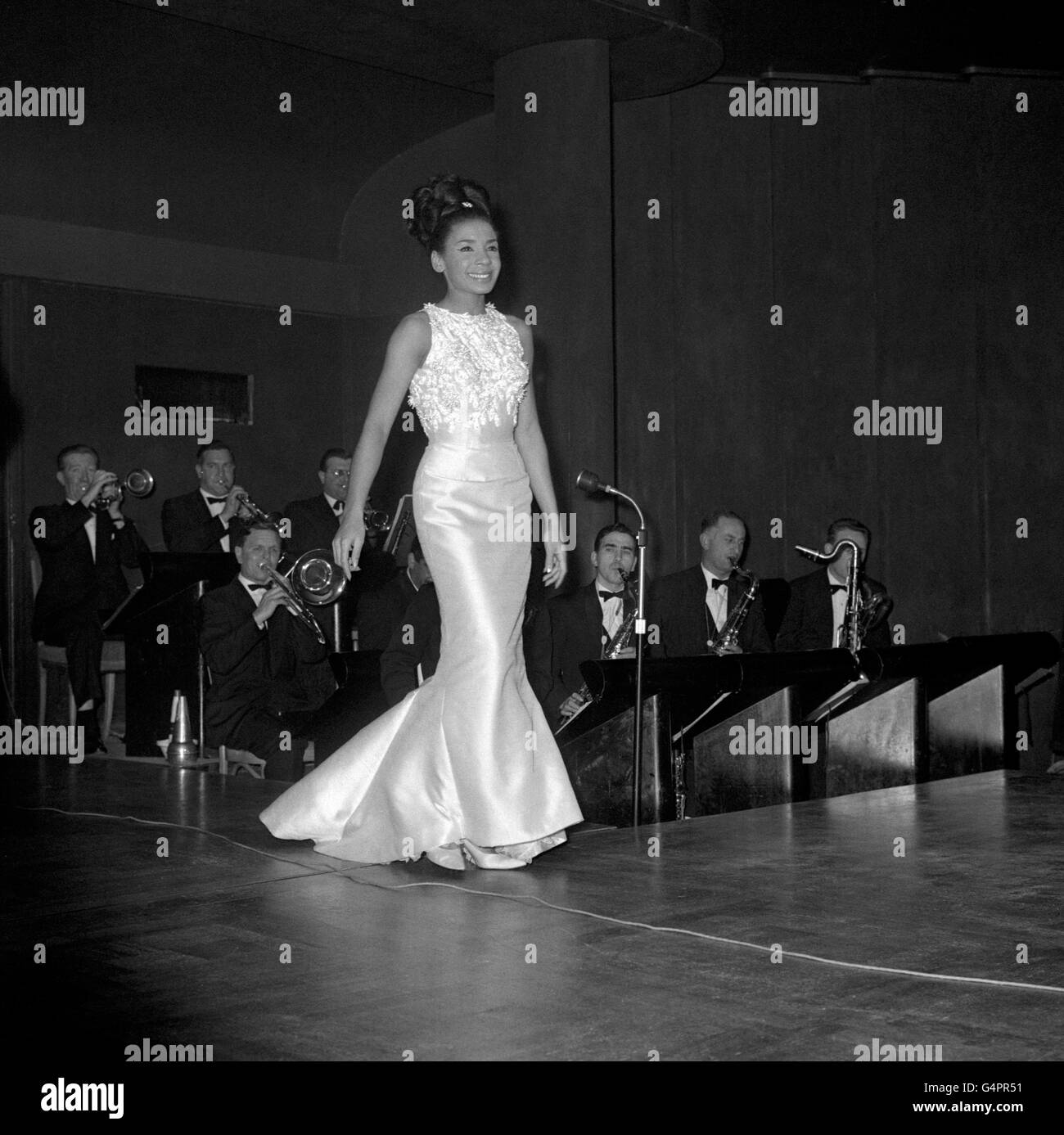 Singer Shirley Bassey on stage during the cabaret at the Savoy Hotel party to celebrate the 10th anniversary of Agatha Christie's play 'The Mousetrap'. A little later, she complained to her audience 'It is like an auction room at the back'. After she had left the floor, her musical director Raymond Long, told the audience 'She is very upset'. Stock Photo