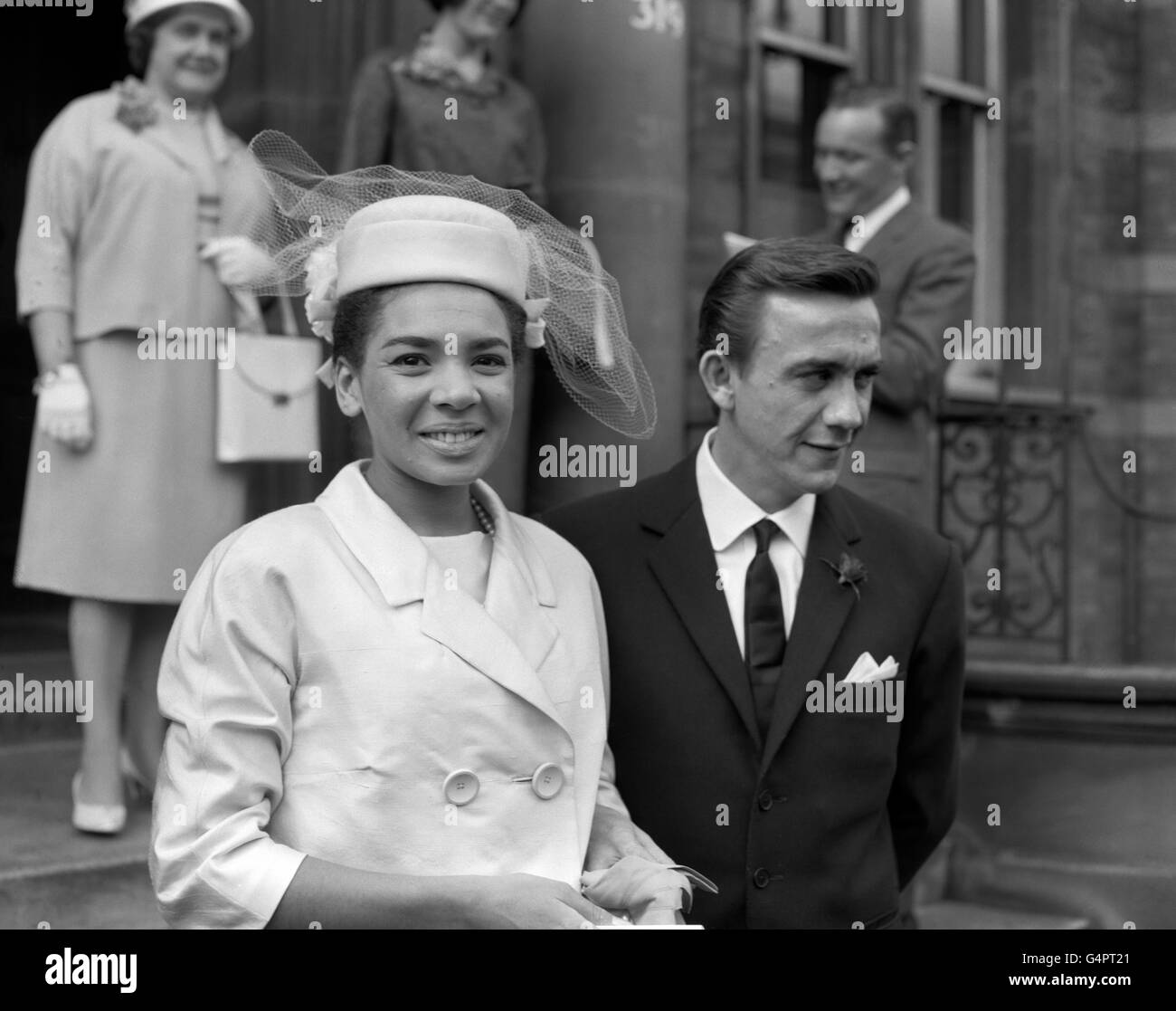 Singer Shirley Bassey, from the Tiger Bay area of Cardiff, and film director Dr. Kenneth Hume, leave after their wedding at Paddington Register office. Shirley is wearing a pink costume with toque hat and veil to match. The Duke of Kent and Miss Katherine Worsley also married on this day. Stock Photo