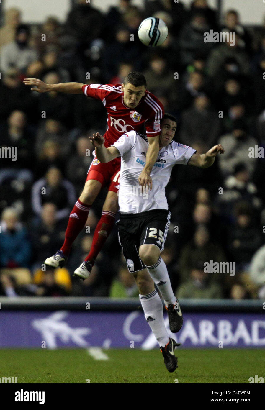Derby County's Callum Ball battles for possession of the ball in the air with Bristol City's James Wilson during the npower Football League Championship match at Pride Park, Derby. Stock Photo