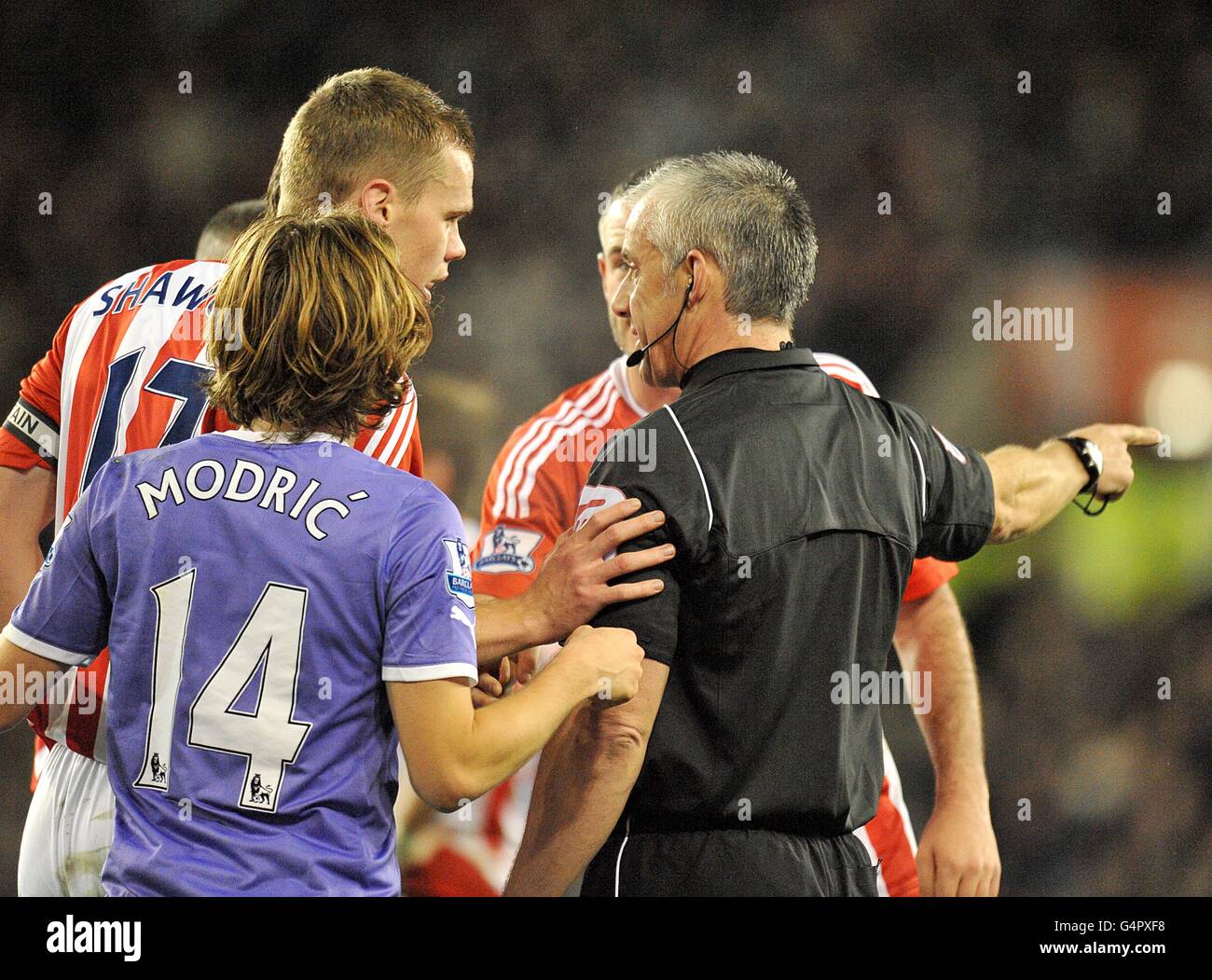 Tottenham Hotspur's Luka Modric (14) and Stoke City's Ryan Shawcross (left) speak with match referee Chris Foy after Tottenham Hotspur are awarded a penalty Stock Photo