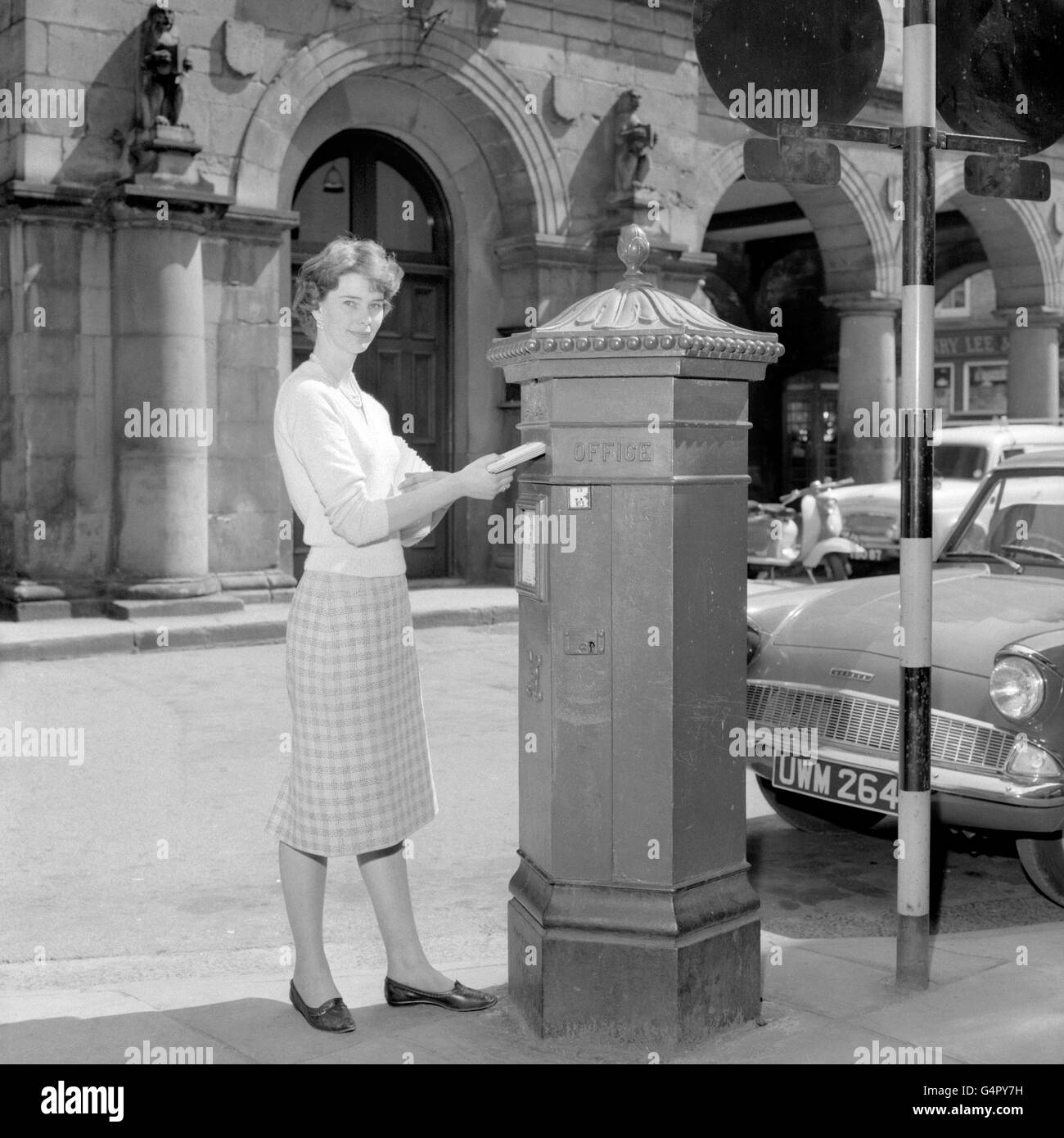 Secretary Angela Moreton posts a letter in an hexagonal shaped post box, one of only 50 made. They were designed by I.W. Penfold and made by Cochrane and Company of Dudley in 1866 Stock Photo