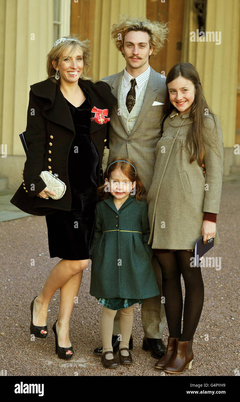 Sam Taylor-Wood proudly wears her OBE with partner Aaron Johnson and her children Angelica (right) and Jessie, after it was presented to her by the Prince of Wales during the Investiture Ceremony at Buckingham Palace in central London. Stock Photo