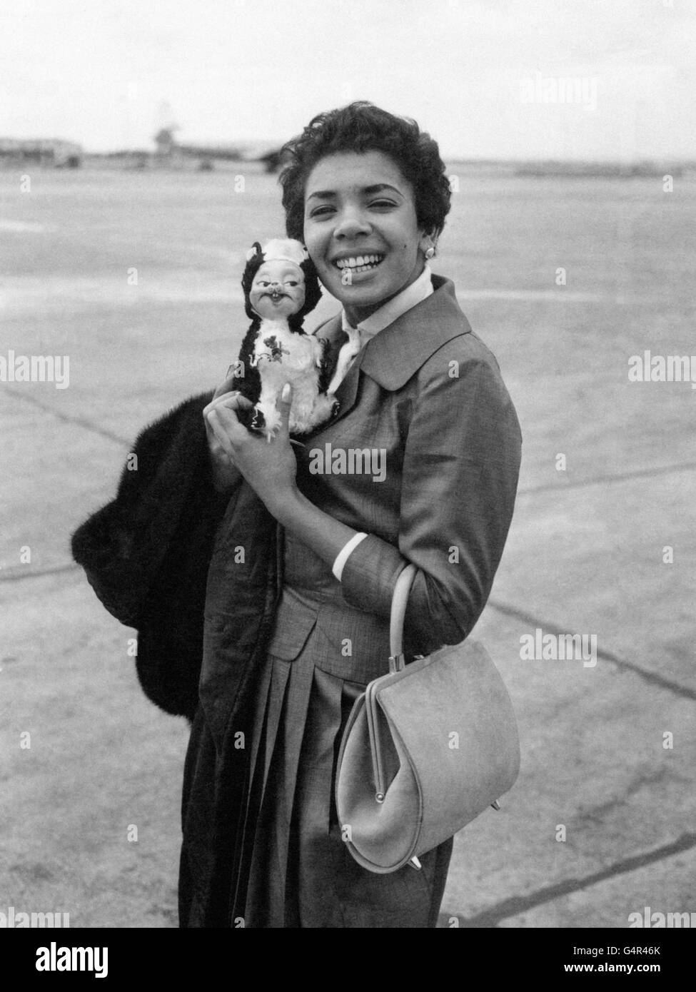 Combining business with pleasure is singer Shirley Bassey who took her mascot with her when she left London Airport by BEA plane for Nice, France. She is en route to Monte Carlo for a weeks holiday and a week in cabaret. Stock Photo