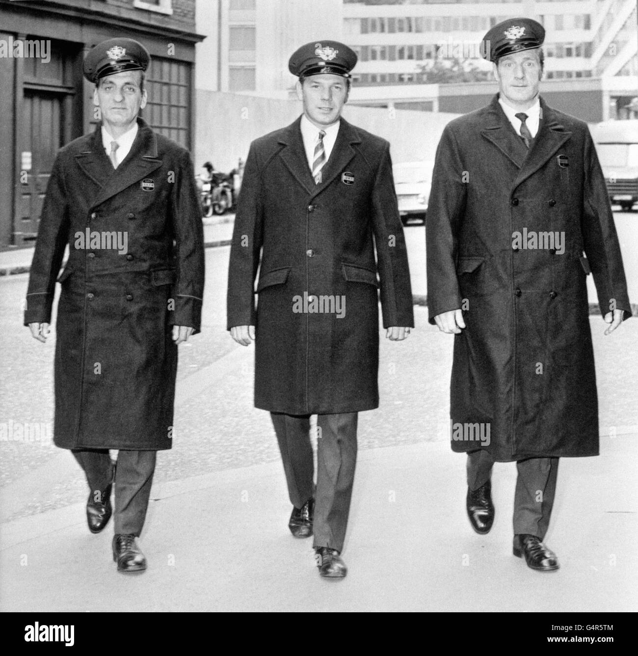 Three postmen style changes in the postman's overcoat. Postman Reg Brown (l) in the red piping coat first issued in 1944, driver Derek Astley (centre) in the new three-quarter length coat to be issued this month, and postman Alf Buxton (r) in the old coat without piping issued in 1969 Stock Photo