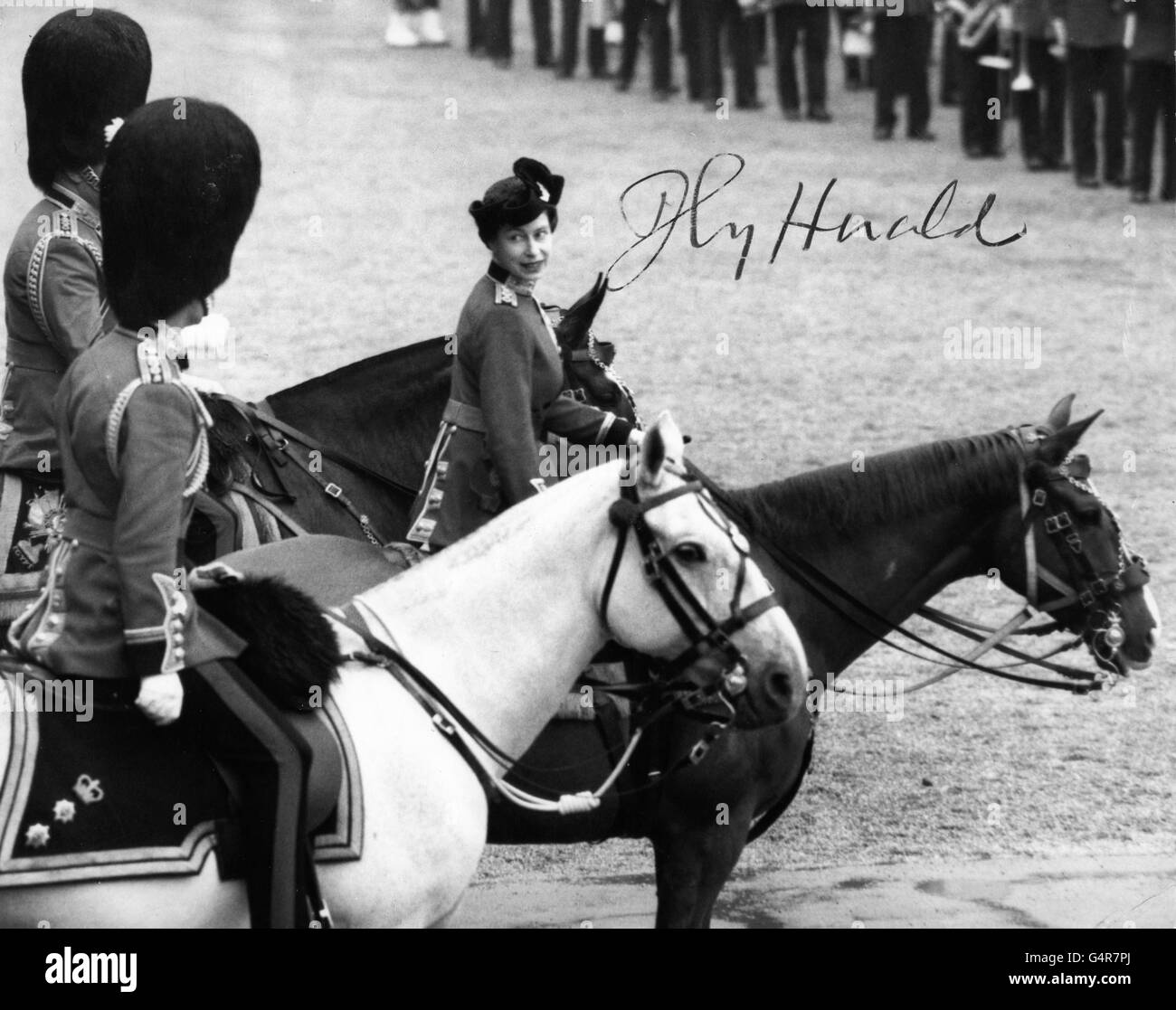 Queen Elizabeth II, riding police horse Imp, turns to smile to the Duke of Edinburgh during the Trooping the Colour ceremony. The parade is held in honour of the Queen's official birthday. Stock Photo