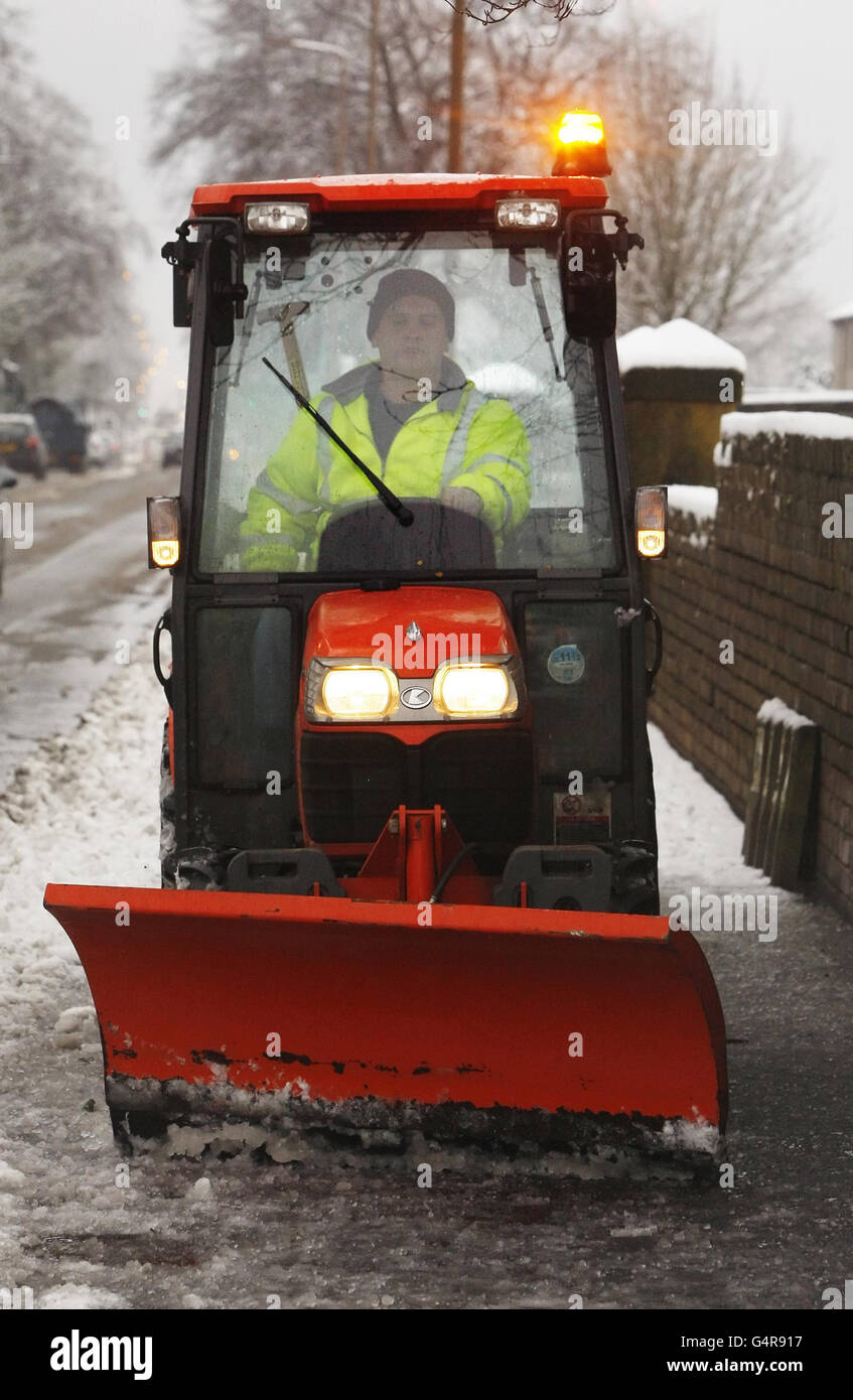 Snow is cleared from a pavement in Whitburn, Scotland, following fresh snow falls overnight. Stock Photo