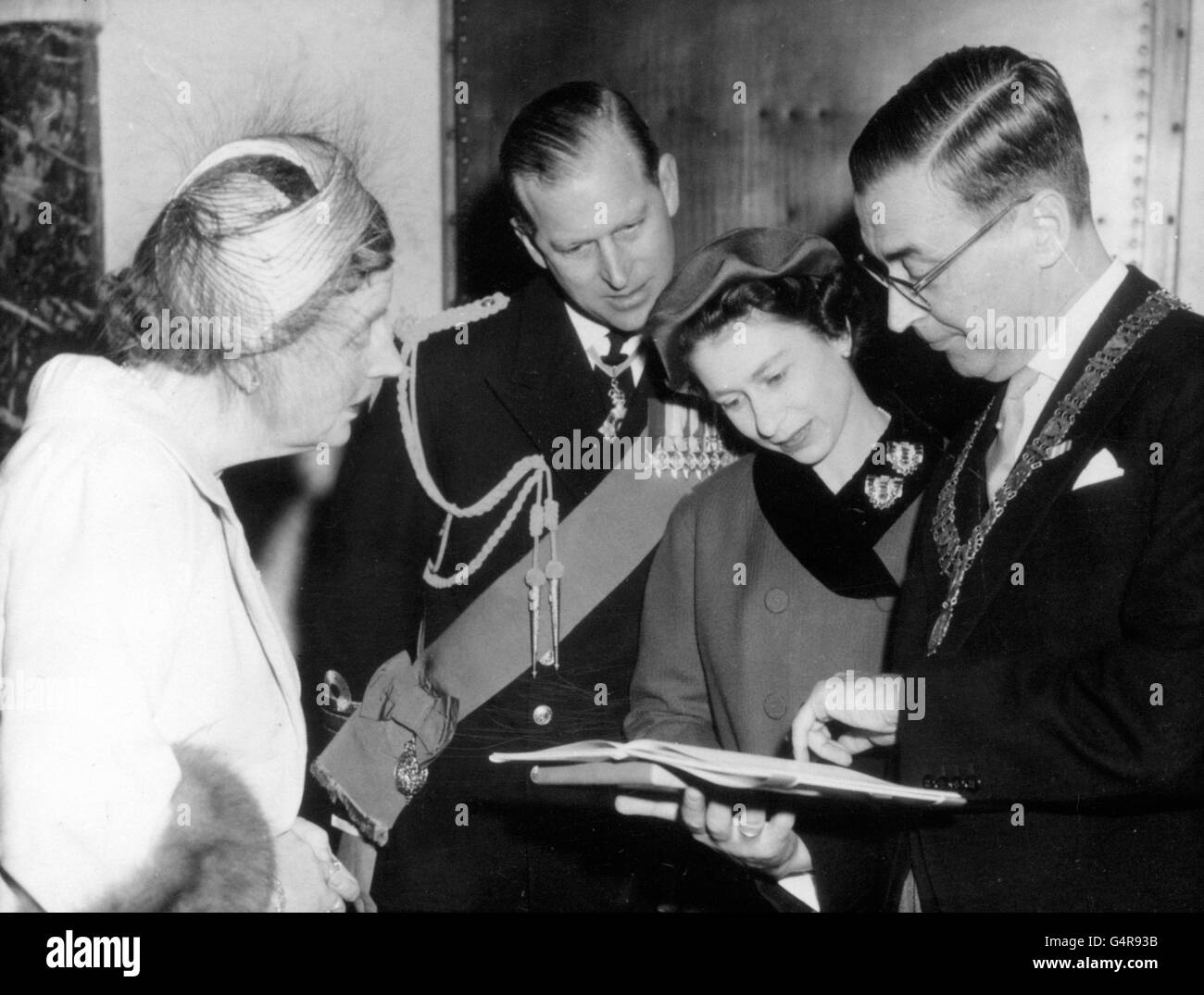 Queen Juliana of the Netherlands watches as the Queen and Duke of Edinburgh are shown a book by the Burgomaster, Mr G van Hall, in Amsterdam Stock Photo