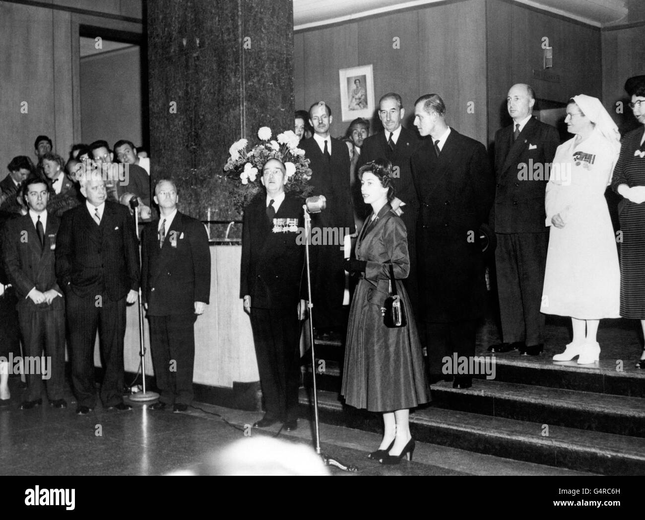 Princess Elizabeth gives a speech during a visit to the 1,500 bed Sunnybrook Hospital, Toronto which is one of the largest military hospitals in the British Empire, during her Royal Tour of Canada. Behind the Princess, looking to his right, is the Duke of Edinburgh. During the visit, the Princess and the Duke talked with veterans of both World Wars and of Korea. Stock Photo