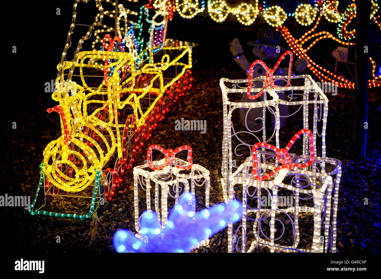 A train and presents are among rope light sculptures sat in the garden at a semi-detached house on Longford Road, Melksham, Wiltshire, as it is lit up by Christmas lights and decorations as some households in the UK enter into the festive spirit. Stock Photo