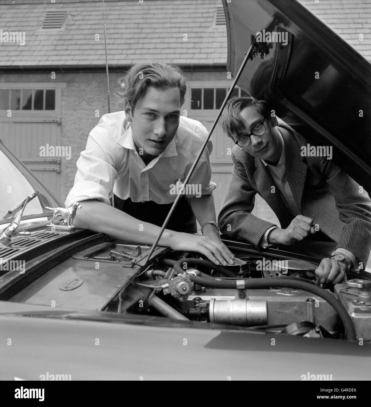 Prince William of Gloucester (left) and younger brother Prince Richard look under the bonnet of his car in the grounds of the family home near Peterborough. Stock Photo