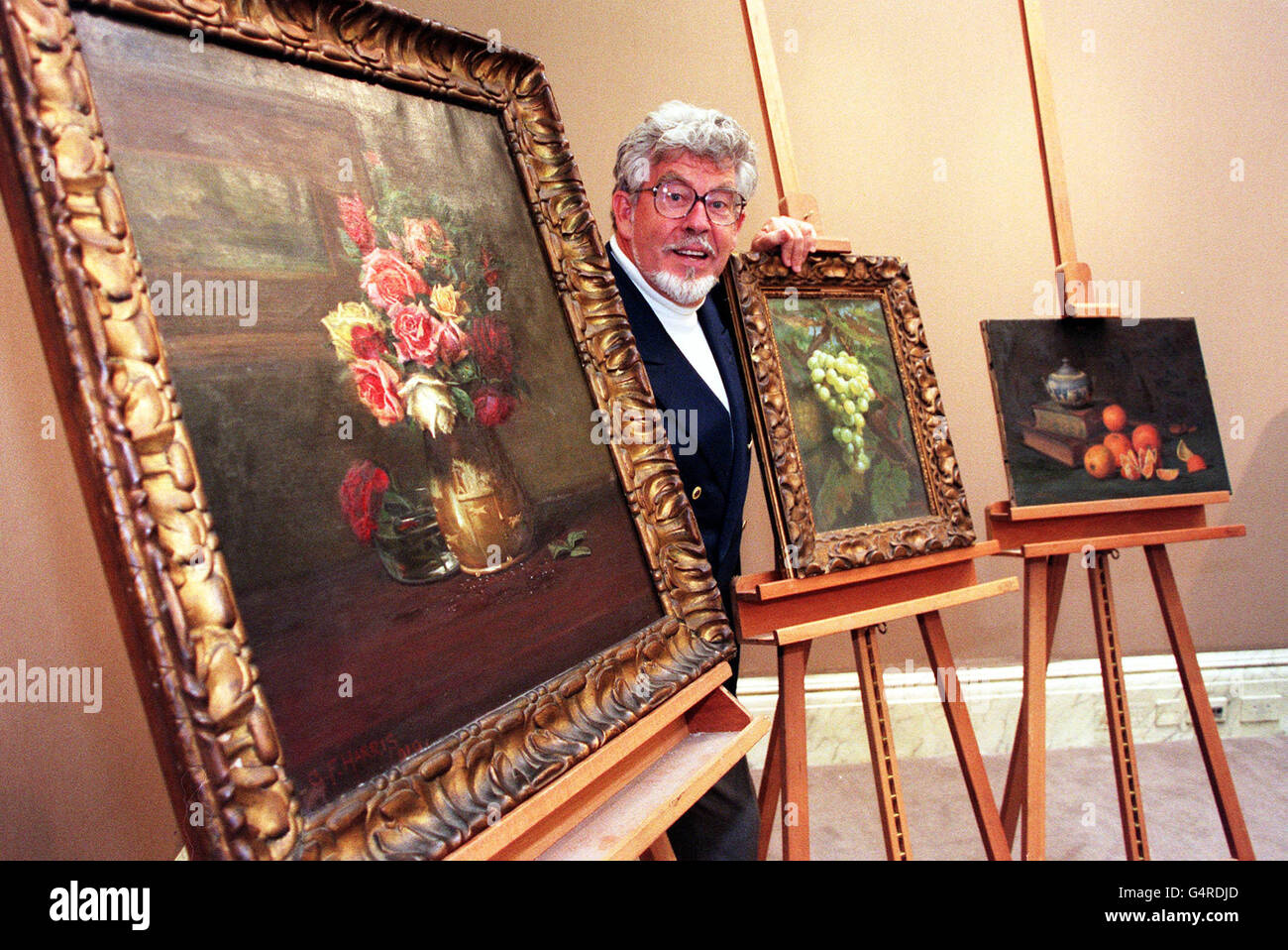 TV presenter and entertainer Rolf Harris with some of his grandfather's paintings at Sotheby's in London. George Harris sold the paintings in 1920 to pay for his trip to Australia, which are due to be auctioned in Sotheby's first Welsh Sale, in Wales on 19-20/10/1999. Stock Photo