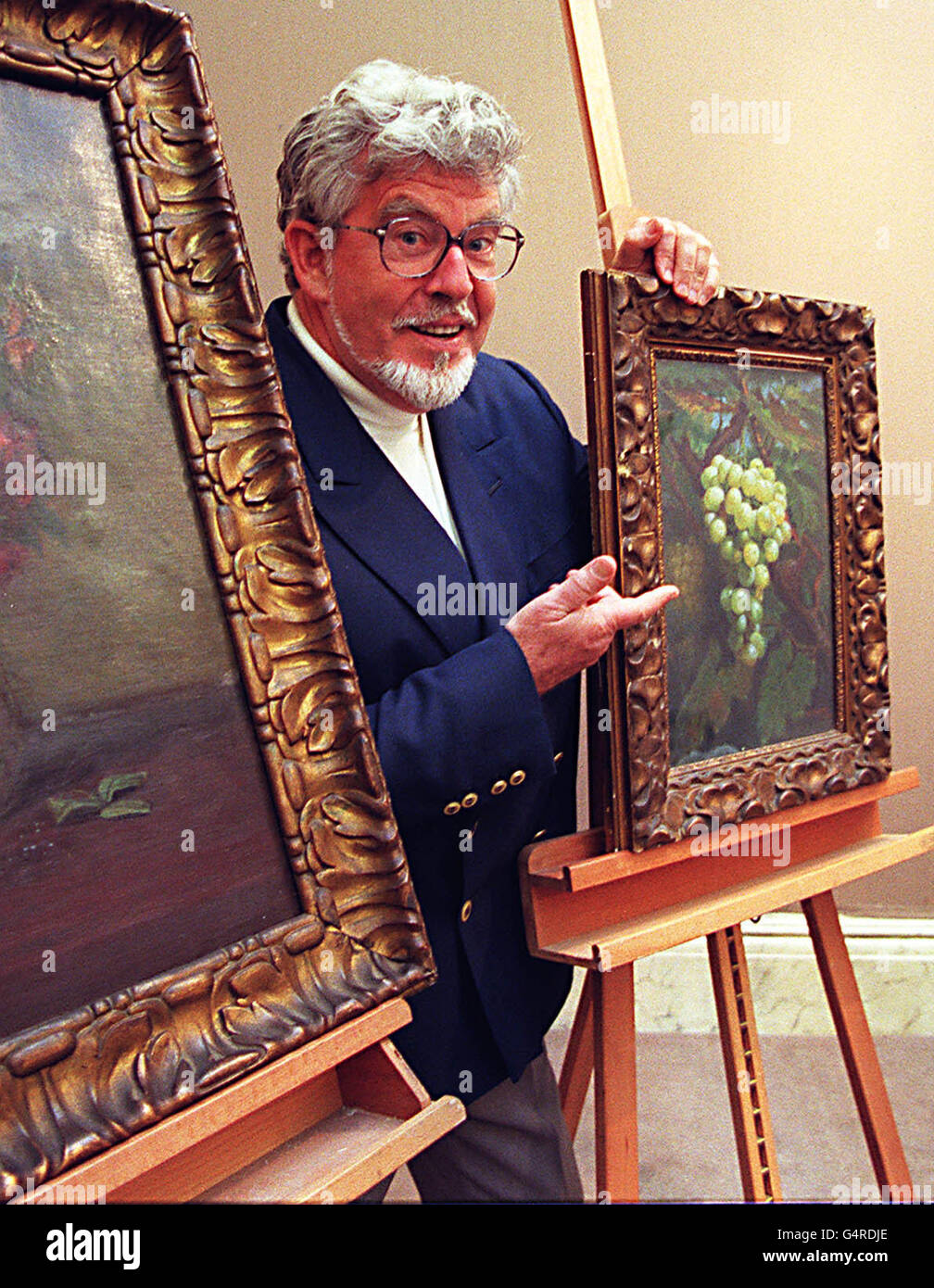 TV presenter and entertainer Rolf Harris with some of his grandfather's paintings at Sotheby's in London. George Harris sold the paintings in 1920 to pay for his trip to Australia, which are due to be auctioned in Sotheby's first Welsh Sale, in Wales on 19-20/10/1999. Stock Photo