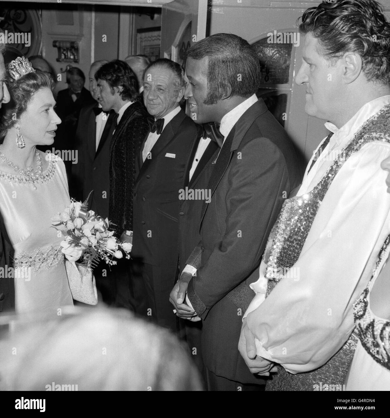 Queen Elizabeth II meeting American singer Lovelace Watkins at the Royal Variety Performance, London Palladium. Next to Watkins are comedians Sid James, left, and Tommy Cooper, right. Stock Photo