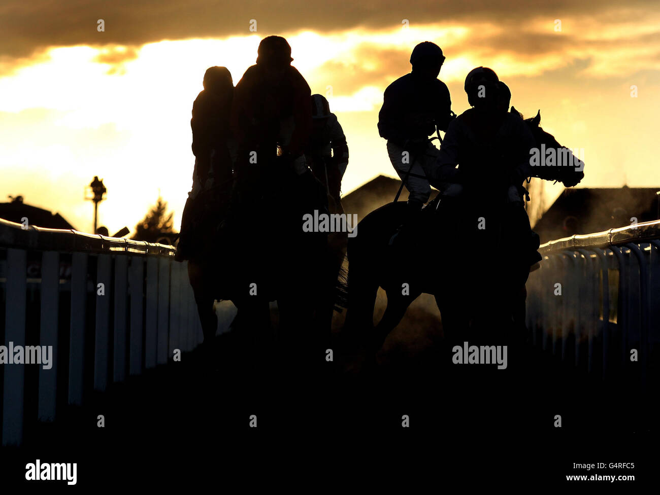 Horse Racing - The International - Day One - Cheltenham Racecourse. A silhouette of runners making their way in after the Citipost Handicap Hurdle during day one of The International at Cheltenham Racecourse. Stock Photo