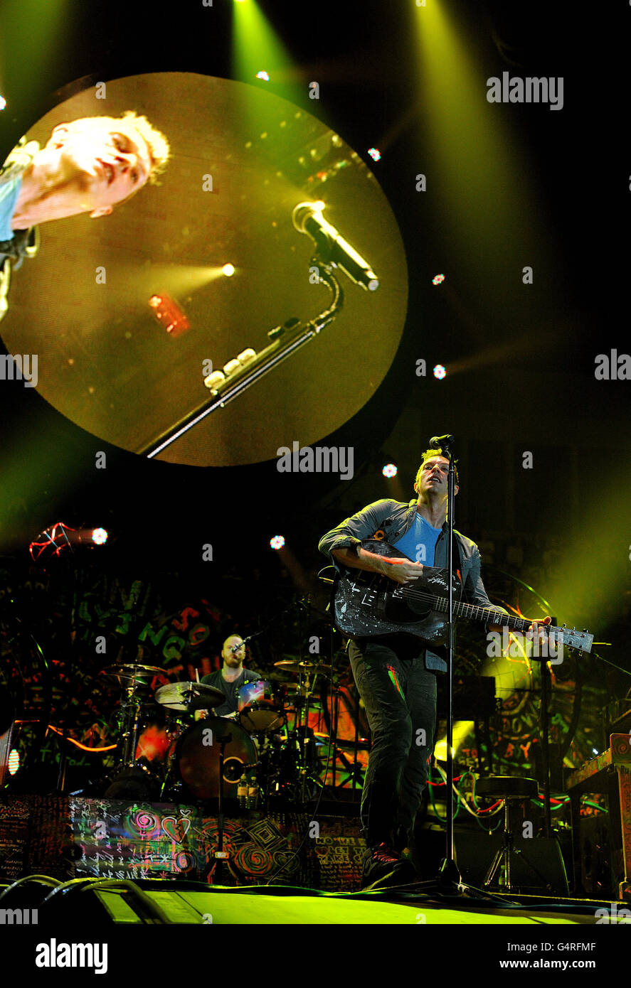 Chris Martin (front) and Will Champion of Coldplay performs as they promote their fifth studio album, Mylo Xyloto, released earlier this year, at The O2 Arena, Greenwich, south London. Stock Photo