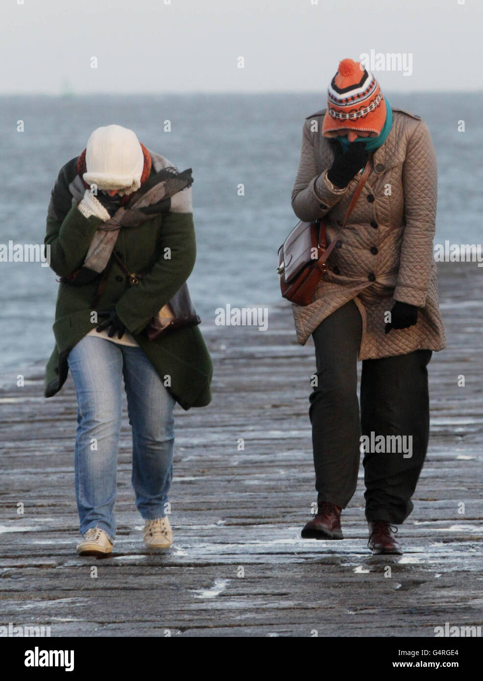 Two women walk along the Great South Wall in Dublin as high winds swept across Ireland and the UK. Stock Photo
