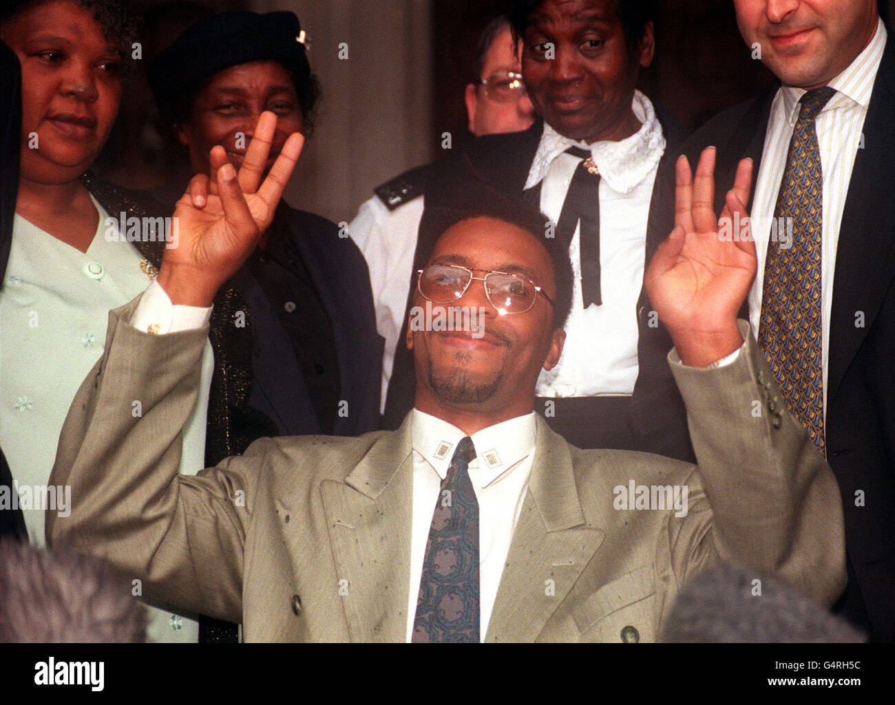 Former boxer Michael Watson celebrates outside the High Court in London after successfully winning the first round of his High Court compensation battle against the British Boxing Board of Control. * Watson suffered brain damage during his super middle-weight bout against Chris Eubank at White Hart Lane, north London, in September 1991 and is suing for damages over the events at the end of a boxing match. Stock Photo
