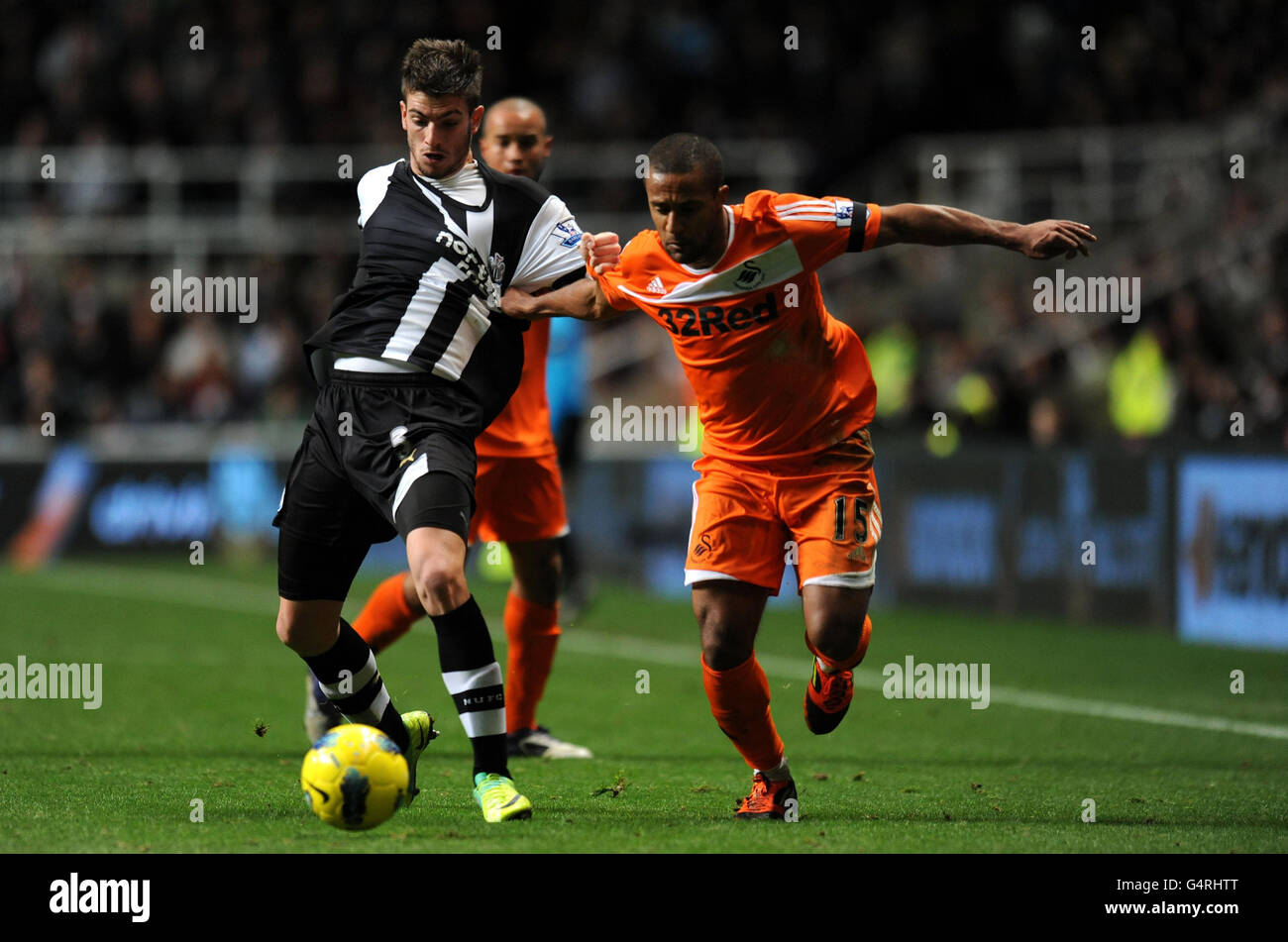 Newcastle's Davide Santon and Swansea's Wayne Routledge (right) in action during the Barclays Premier League match at the Sport Direct Arena, Newcastle. Stock Photo