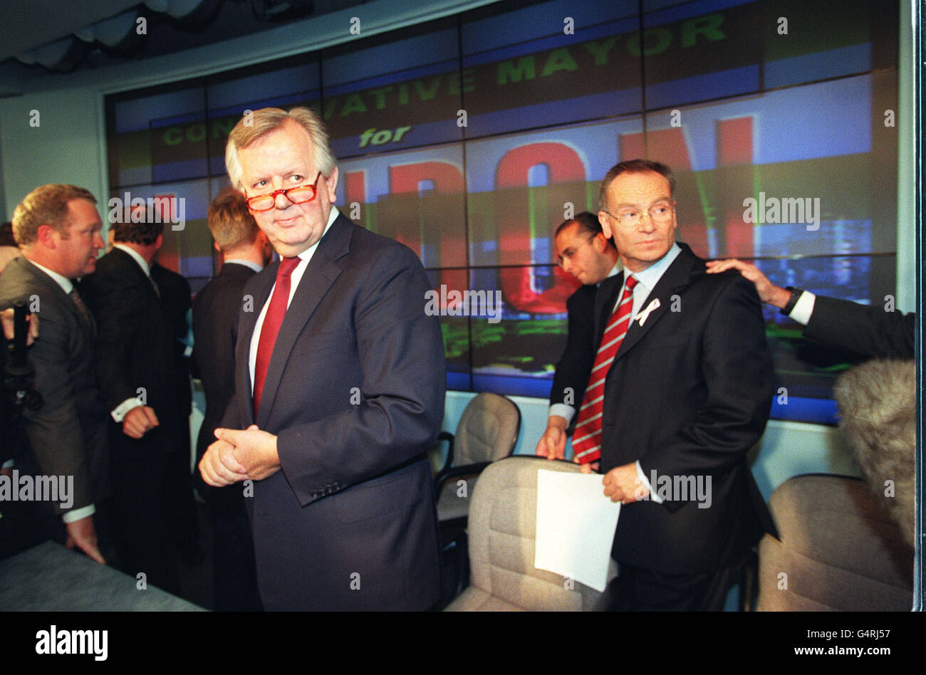 A journalist holds the shoulder of millionaire novelist Lord Archer to