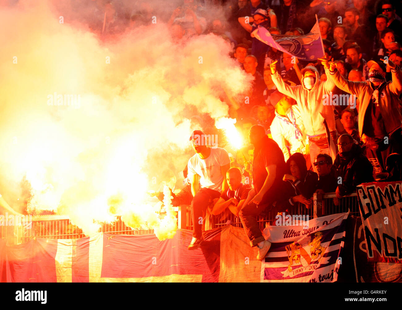 Fans of Hertha BSC Berlin lighting flares and throwing them onto the pitch, rioting during the second leg relegation match Stock Photo