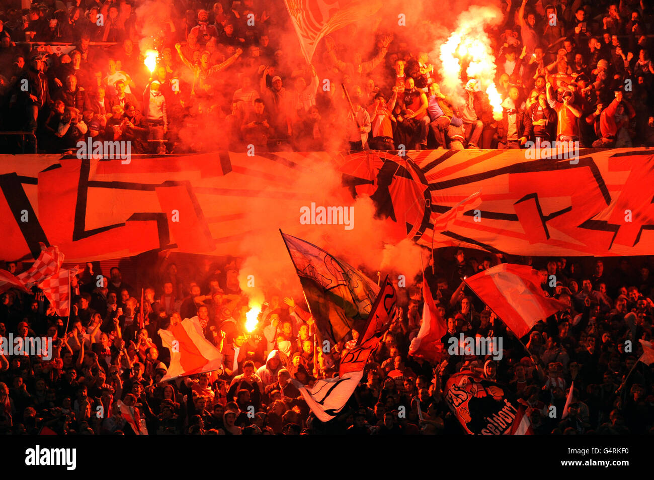 Flares are lit in the Fortuna Duesseldorf fan section during the second leg relegation match between Fortuna Duesseldorf and Stock Photo