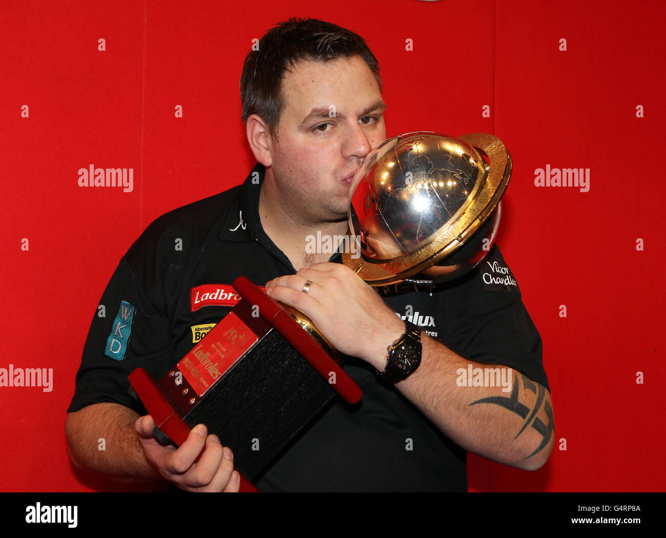 Adrian Lewis celebrates with his trophy after defeating Andy Hamilton during the