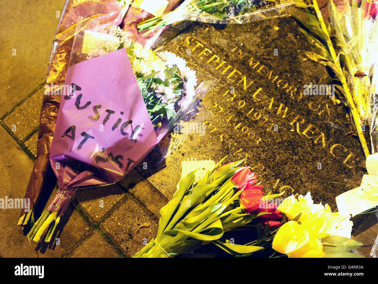 Flowers and tributes are left on the memorial stone for Stephen Lawrence on Well Hall Road, Eltham in London, following the conviction of Gary Dobson, 36, and David Norris for his murder. Stock Photo