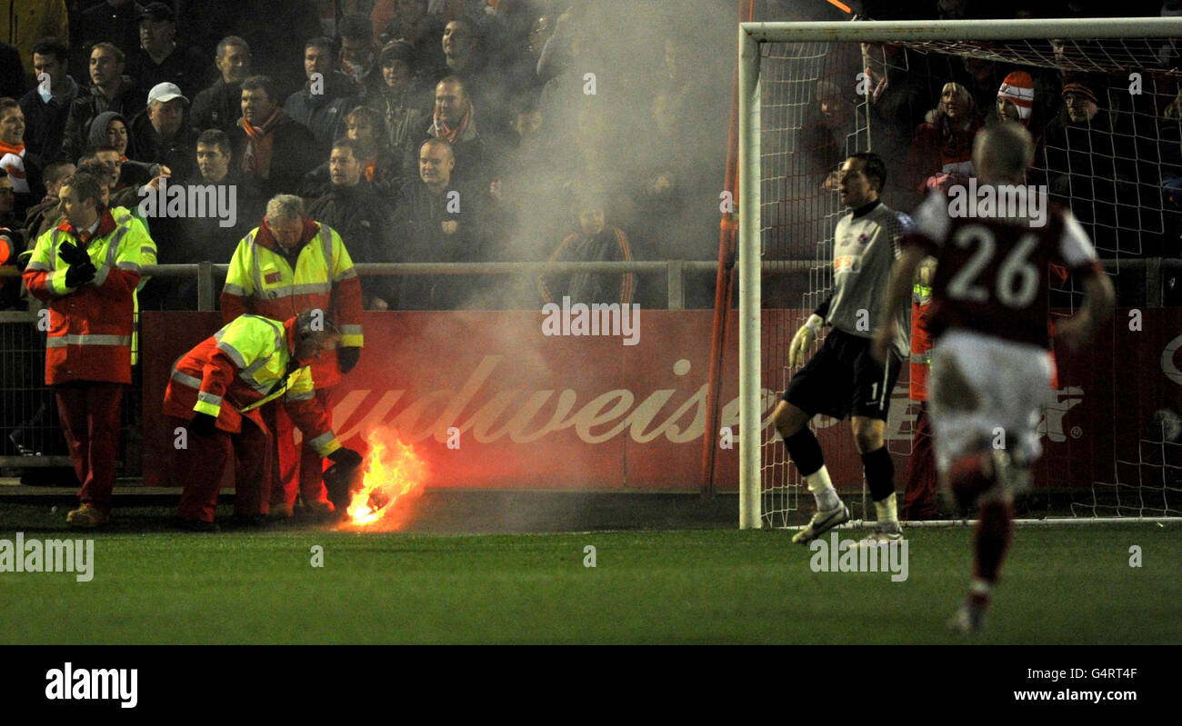 A flare catches on fire near the goal of Fleetwood Town's Scott Davies after Blackpool fans lit it in the stands during the FA Cup, Third Round match at Highbury Stadium, Fleetwood. Stock Photo