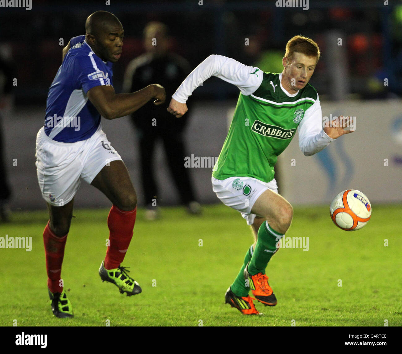 Hibernian's Eion Doyle and Cowdenbeath's Joe Mbu (left) battle for the ball during the Scottish Cup, Fourth Round match at Central Park, Cowdenbeath. Stock Photo
