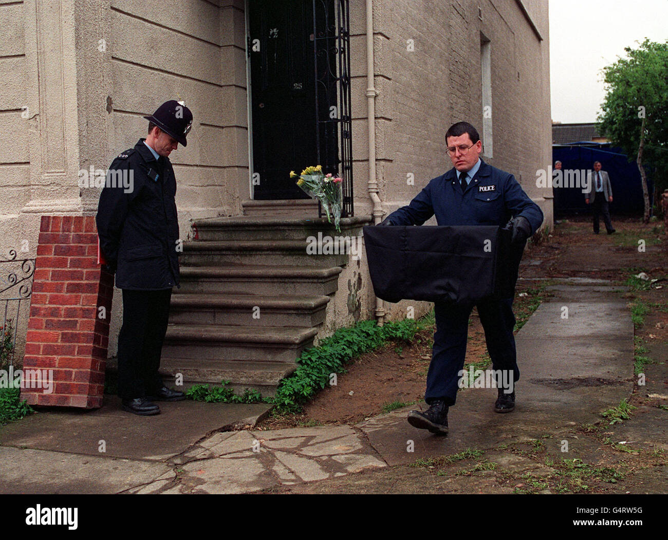 A policeman carries the remains of a young woman from the former home of Frederick West. 25 Midland Road, Gloucester. Fred West has been charged with the murders of 10 women. Stock Photo