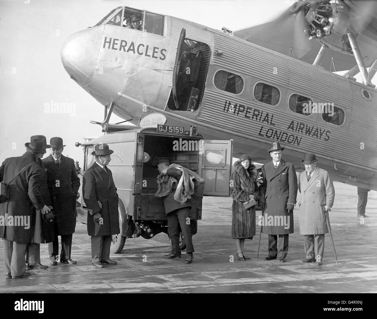 Christmas mail is loaded aboard the Imperial Airways flight headed for South Africa and North & East Rhodesia. South African High Commissioner to Britain Charles te Water, with his wife, beside the aeroplane while it is being loaded with the mail Stock Photo