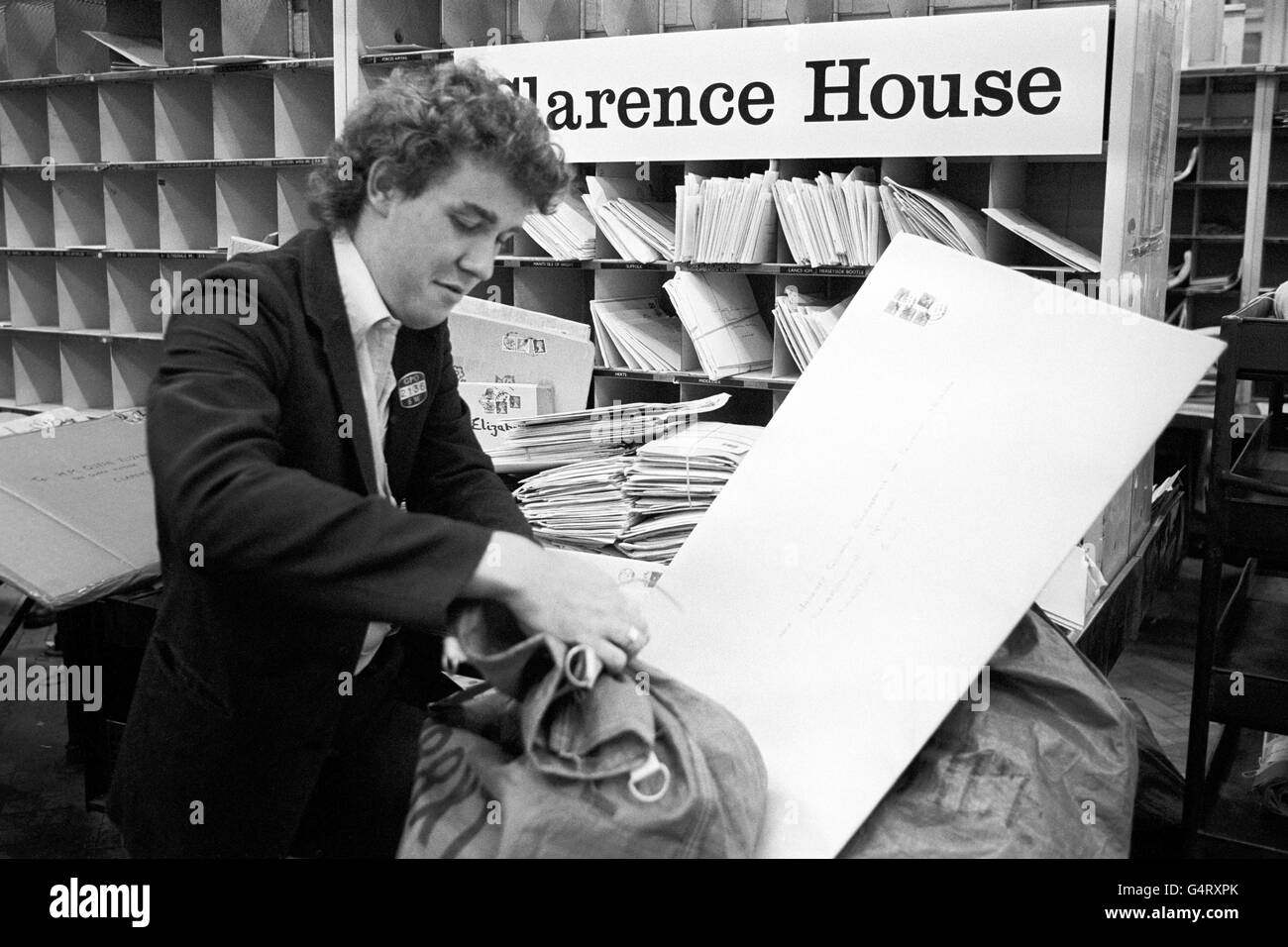 Postman Barry Bolton ties up a mail bag at the South Western Sorting Office, Victoria, which will be delivered to the Queen Mother at Clarence House. The bag contains birthday mail, she has been receiving 2000 cards a day Stock Photo
