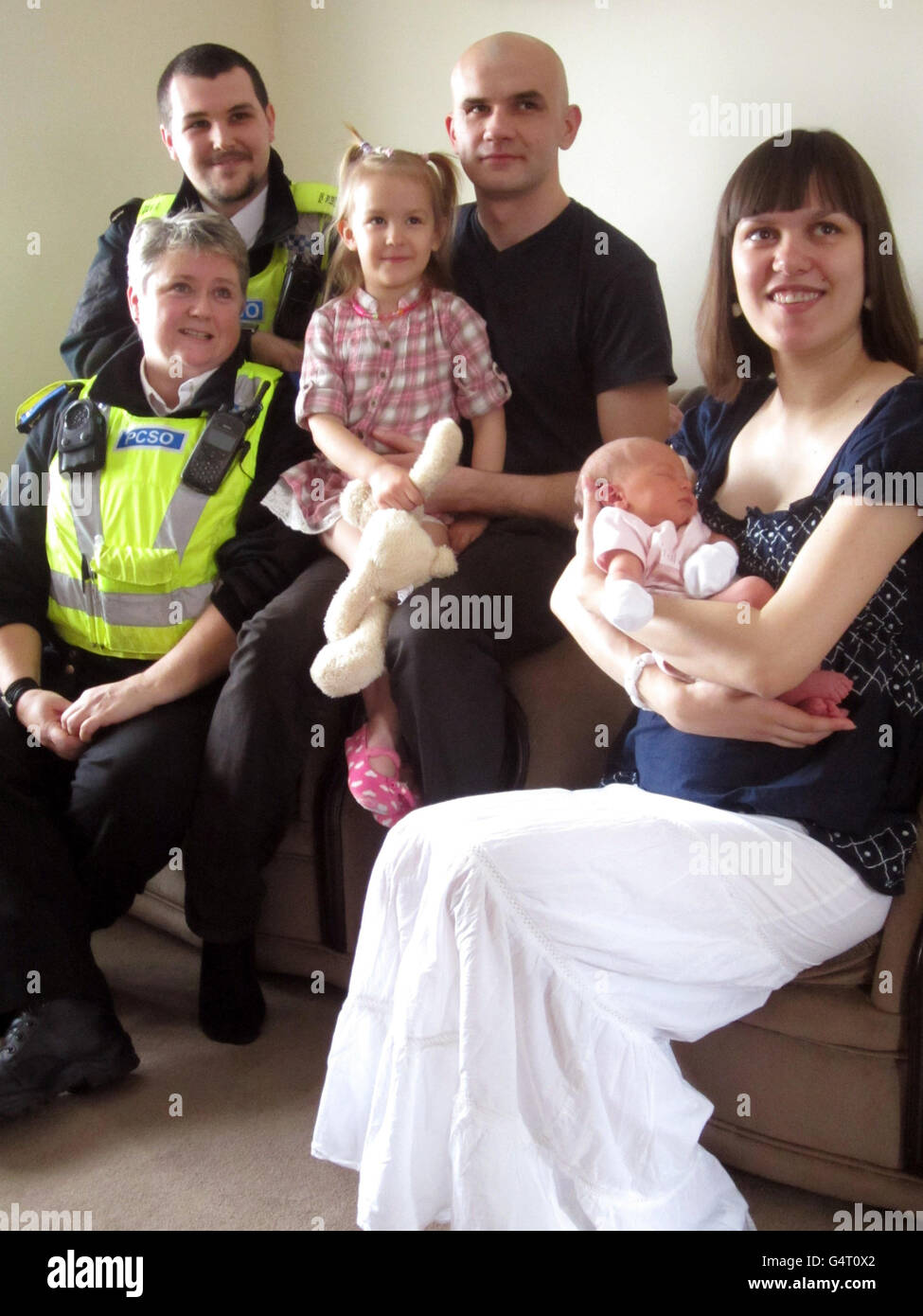 Baby girl Viktorija Munkova is held by her mother Inga Munkova with father Dmitrijs Frolovs, her sister Laura Munkova and PSCO's Sam Dyer and Donna Thompson who helped deliver Viktorija by the roadside after Inga was diverted from King's Lynn hospital - which is five minutes from her home - to Peterborough due to overcrowding after her contractions began on Saturday. Stock Photo