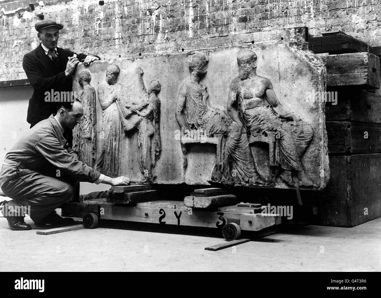 A panel from the Elgin Marbles being handled by porters after being stored in an underground tunnel for safety during the Second World War. The marbles date from 432BC and formerly graced the Parthenon on the Athenian Acropolis. *The picture shows the centre slab of the frieze of the Elgin marbles featuring the patron goddess of Athens, Athena. The marbles also depict gods and mortals attending the Panatheniac procession held annually in the city of Athens to celebrate the birthday of Athena. *20/11/1999 - A reported call by President Clinton to return the Elgin marbles to Greece was angrily Stock Photo