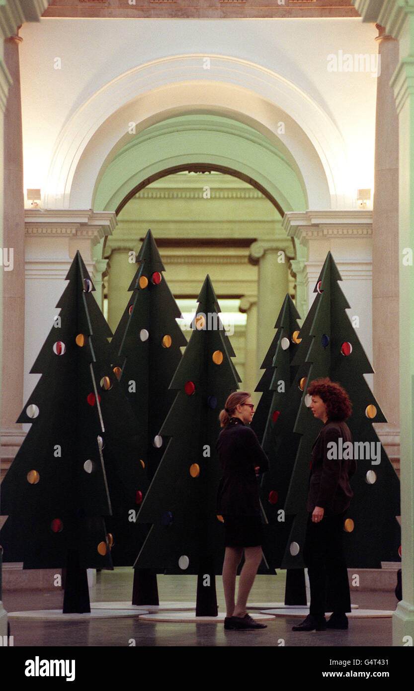 Members of the public view 'A Christmas Forest' designed by artist Julian Opie at the Tate Gallery in London. The gallery has broken with tradition of having a single tree on display this year by showing the Xmas trees in the rotunda. Stock Photo